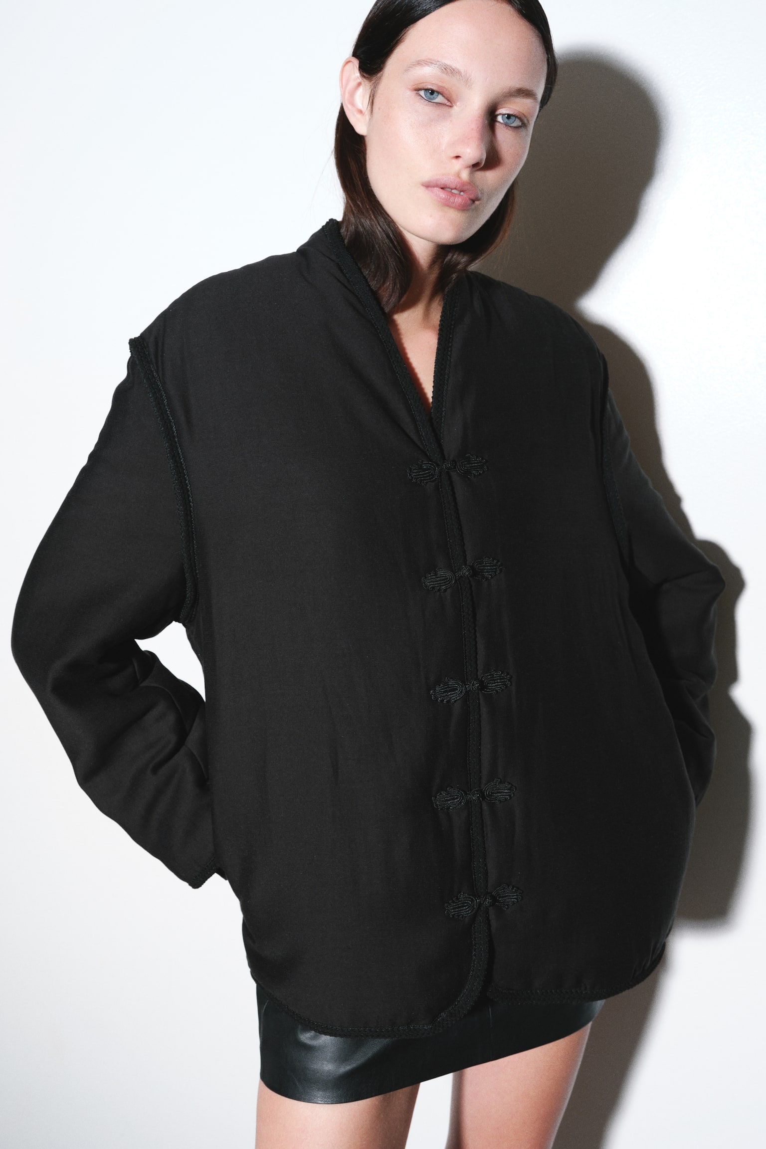 ÐÐ¾Ð´ÐµÐ»Ñ Ð¾Ð´ÑÐ³Ð½ÐµÐ½Ð° Ð² ÑÐ¾ÑÐ½Ñ oversize-ÐºÑÑÑÐºÑ Ð· Ð»ÐµÐ³ÐºÐ¸Ð¼ ÑÑÐµÐ¿Ð»ÐµÐ½Ð½ÑÐ¼, V-Ð¿Ð¾Ð´ÑÐ±Ð½Ð¸Ð¼ Ð²Ð¸ÑÑÐ·Ð¾Ð¼ Ñ Ð¿ÐµÑÐµÐ´Ð½ÑÐ¼Ð¸ ÒÑÐ´Ð·Ð¸ÐºÐ°Ð¼Ð¸ Ñ Ð²Ð¸Ð³Ð»ÑÐ´Ñ Ð²ÑÐ·Ð»ÑÐ². ÐÐ¾Ð´ÐµÐ»Ñ ÑÑÐ¾ÑÑÑ, Ð¿Ð¾ÐºÐ»Ð°Ð²ÑÐ¸ ÑÑÐºÐ¸ Ð² Ð±Ð¾ÐºÐ¾Ð²Ñ ÐºÐ¸ÑÐµÐ½Ñ ÐºÑÑÑÐºÐ¸, ÑÐºÑ ÑÑÐ¸Ð»ÑÐ·Ð¾Ð²Ð°Ð½Ð¾ Ð· ÑÐ¾ÑÐ½Ð¸Ð¼ Ð²Ð¸ÑÐ¾Ð±Ð¾Ð¼, ÑÑÐ¾Ð¶Ð¸Ð¼ Ð½Ð° ÑÐºÑÑÑ, Ð²Ð¸Ð´Ð¸Ð¼Ð¸Ð¼ Ñ Ð·Ð¾Ð½Ñ ÑÐ°Ð»ÑÑ. - 1