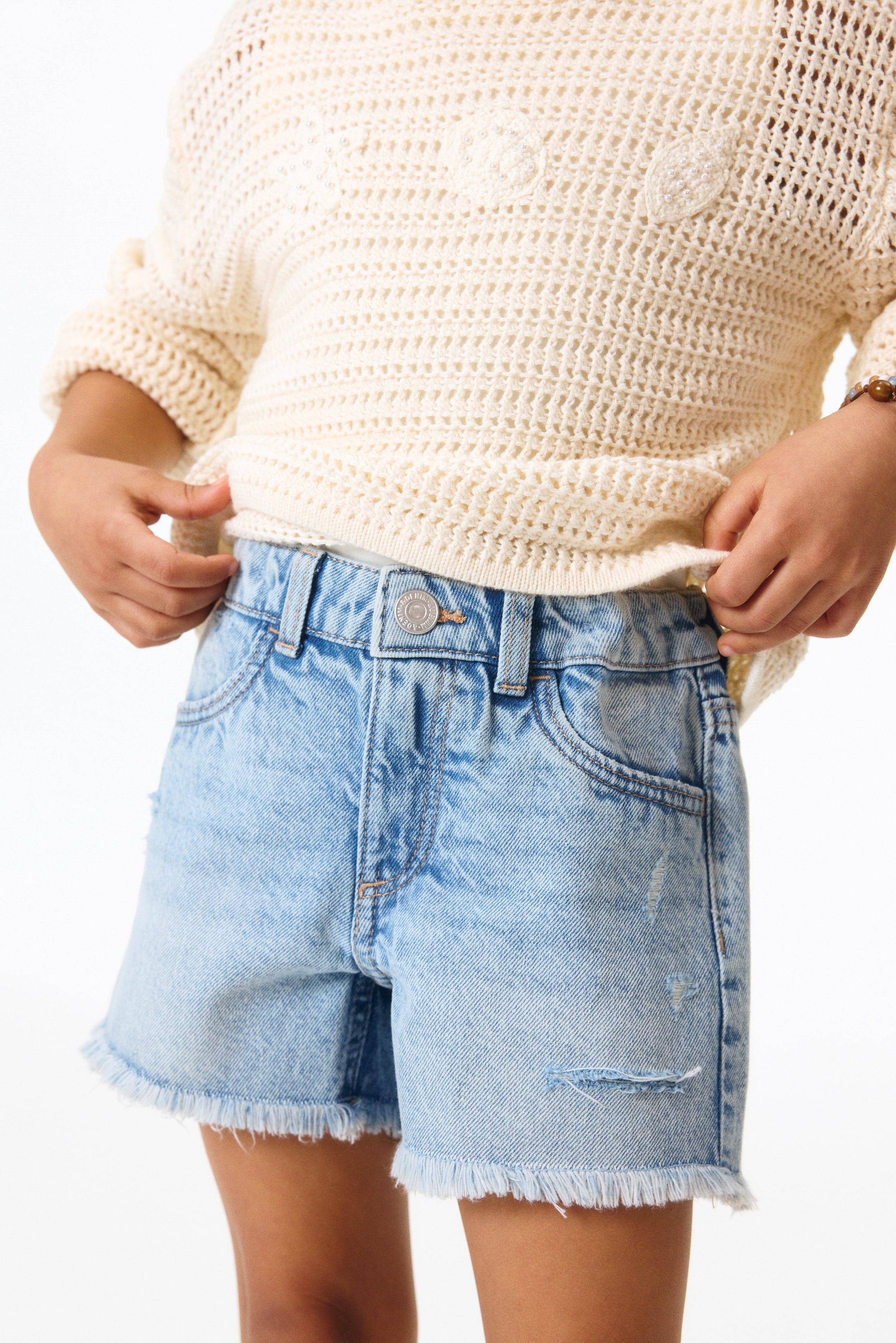 Short frangé en denim