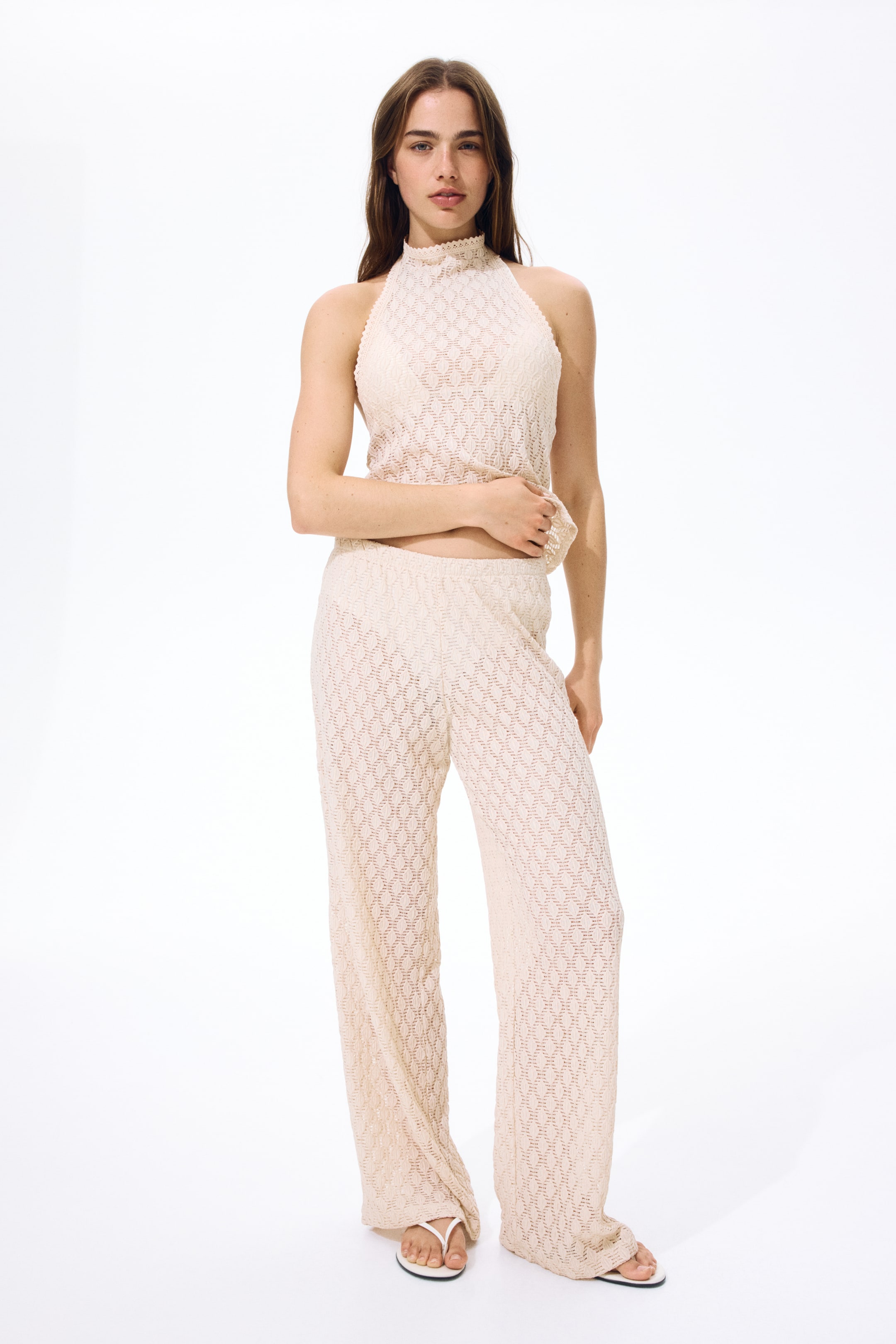 Agrandir l'image: Les pantalons à coupe décontractée sont présentés de face, avec un jersey effet dentelle doté d'une taille haute élastiquée et de jambes droites.
