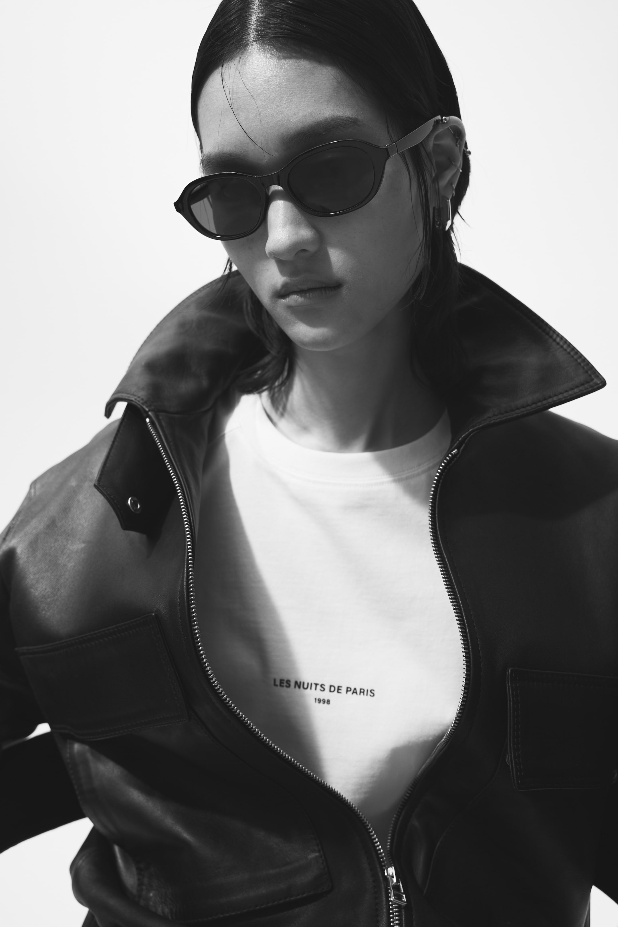 View larger image: The model is sporting oval sunglasses featuring plastic frames and sidepieces, complemented by tinted, UV-protective plastic lenses.