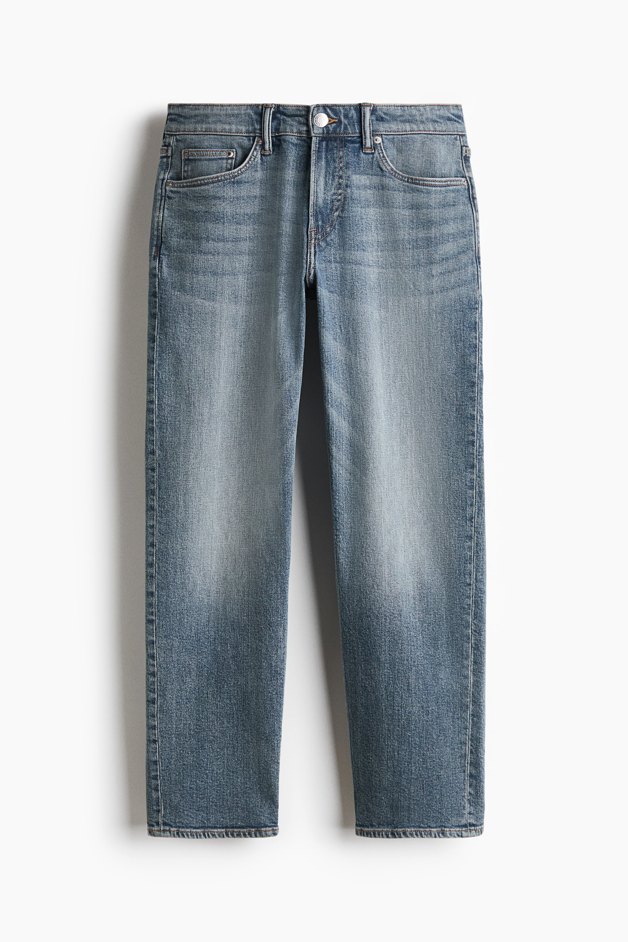 View larger image: A pair of medium-wash blue denim jeans is hanging in a front view, displaying a regular waist with belt loops and a button fastening. The straight legs show light fading down the thighs and knees, highlighting the classic five-pocket design.
