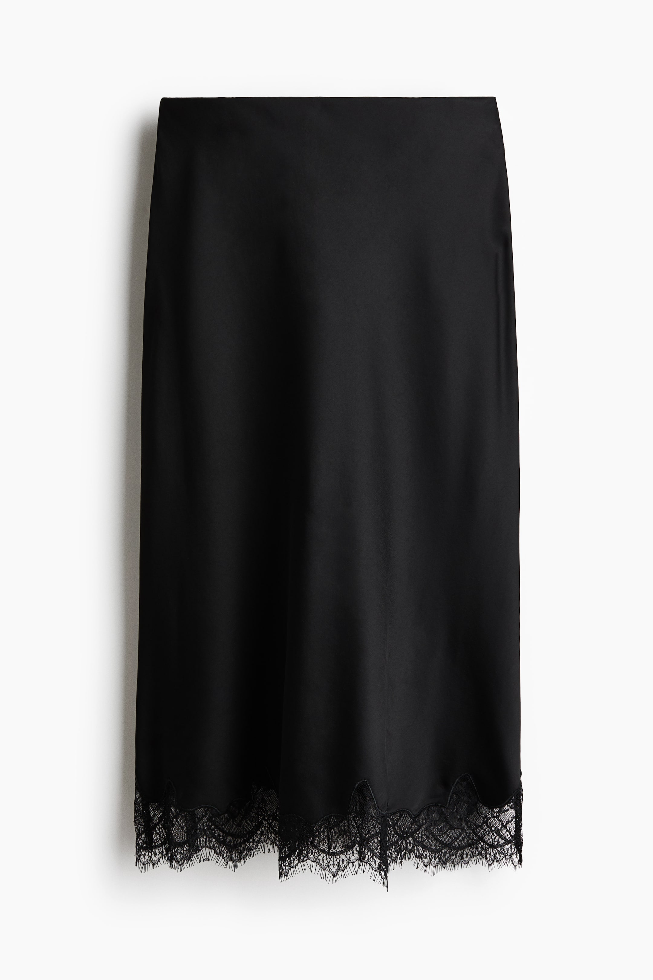 הצגת תמונה גדולה יותר: חצאית שחורה באורך מידי מוצגת מלפנים, עשויה מבד ארוג המעניק ברק קל. שולי החצאית הישרים מעוטרים בתחרה גזורה.