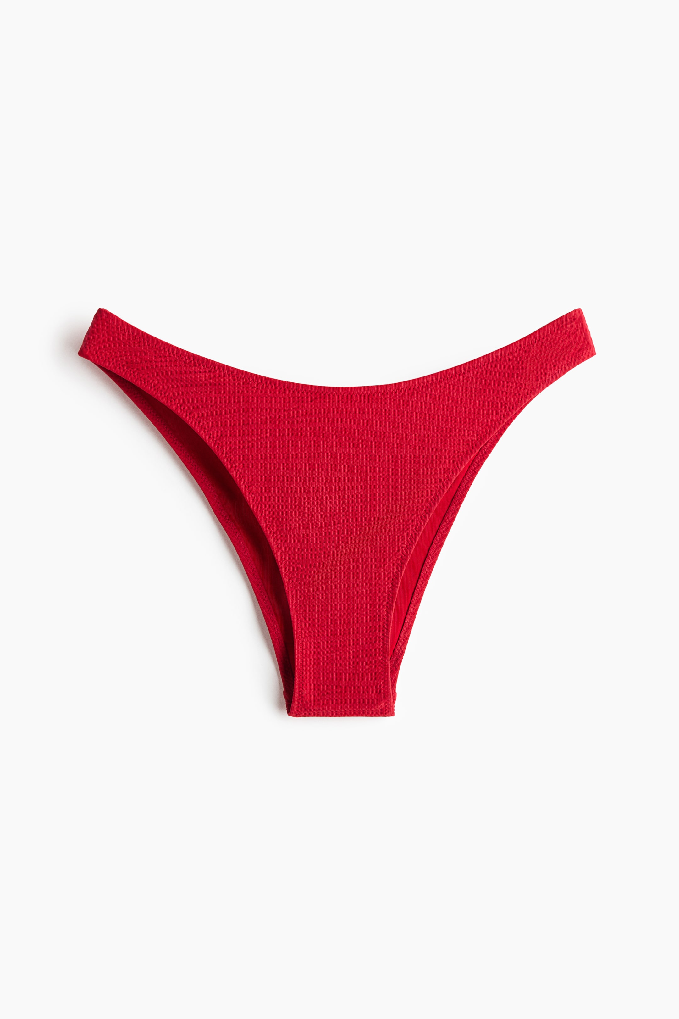 View larger image: A red crinkled bikini bottom is laid out flat, showcasing its front with a low, curved waistband and high-cut leg openings.