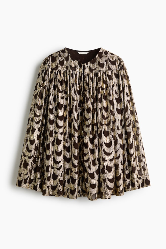 A front-facing gathered blouse is featuring a dark brown fabric adorned with a metallic gold scallop pattern. The blouse is displaying a round neckline, a gathered yoke creating a voluminous, pleated drape, and long, wide sleeves. - 1