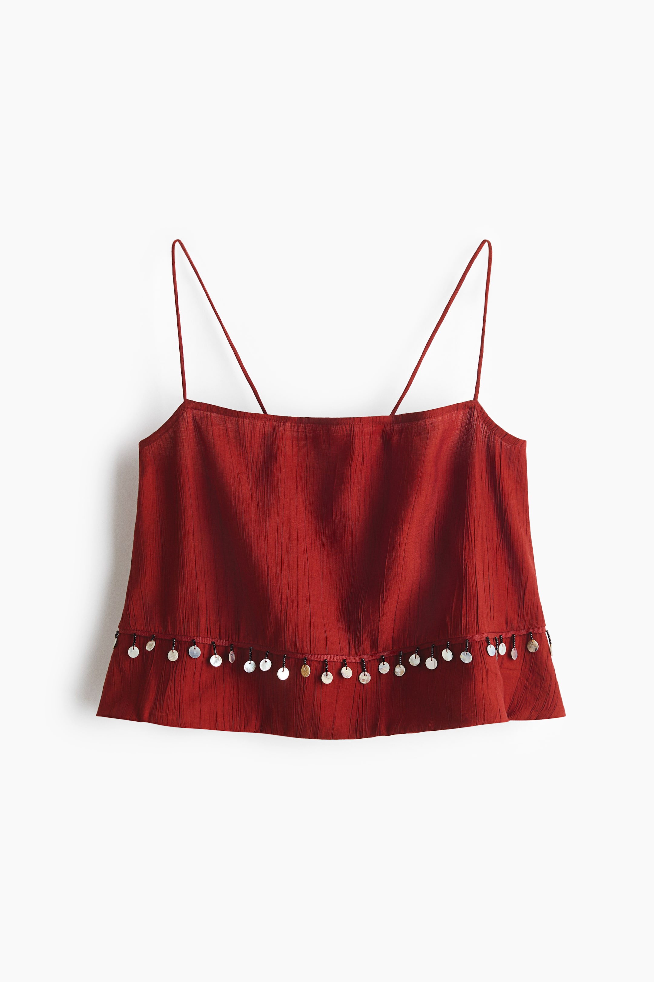 View larger image: A short reddish-brown beach top is showcased from the front, featuring a crinkled viscose-blend weave and a straight neckline. Spaghetti shoulder straps extend upwards, with small plastic beads and pearly sequins embellishing the seam above the hem.