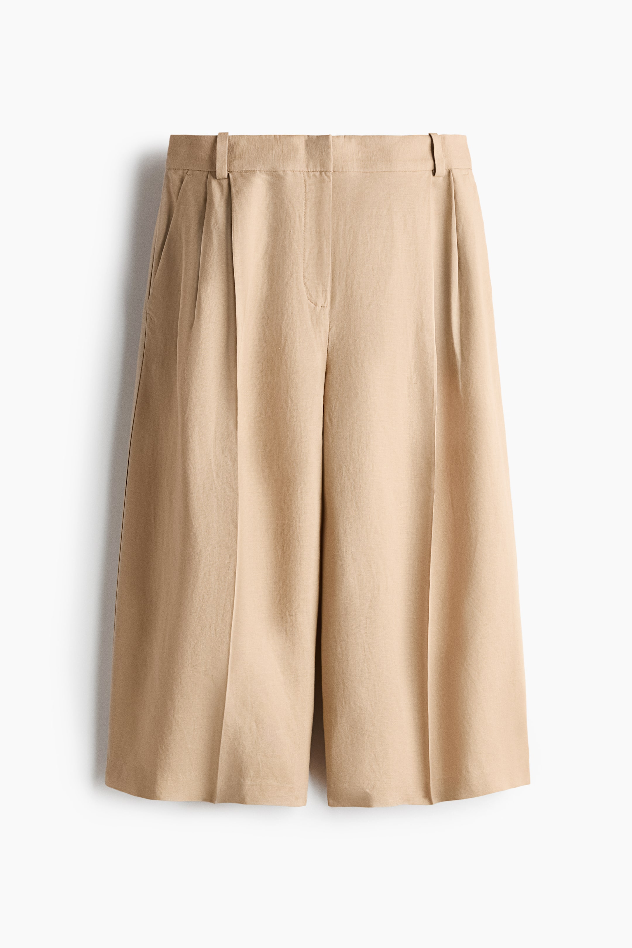 View larger image: Loose-fit culottes are displayed from the front, featuring a zip fly with a concealed hook-and-bar fastening and diagonal side pockets. Wide legs showcase pleats and creases down the front.