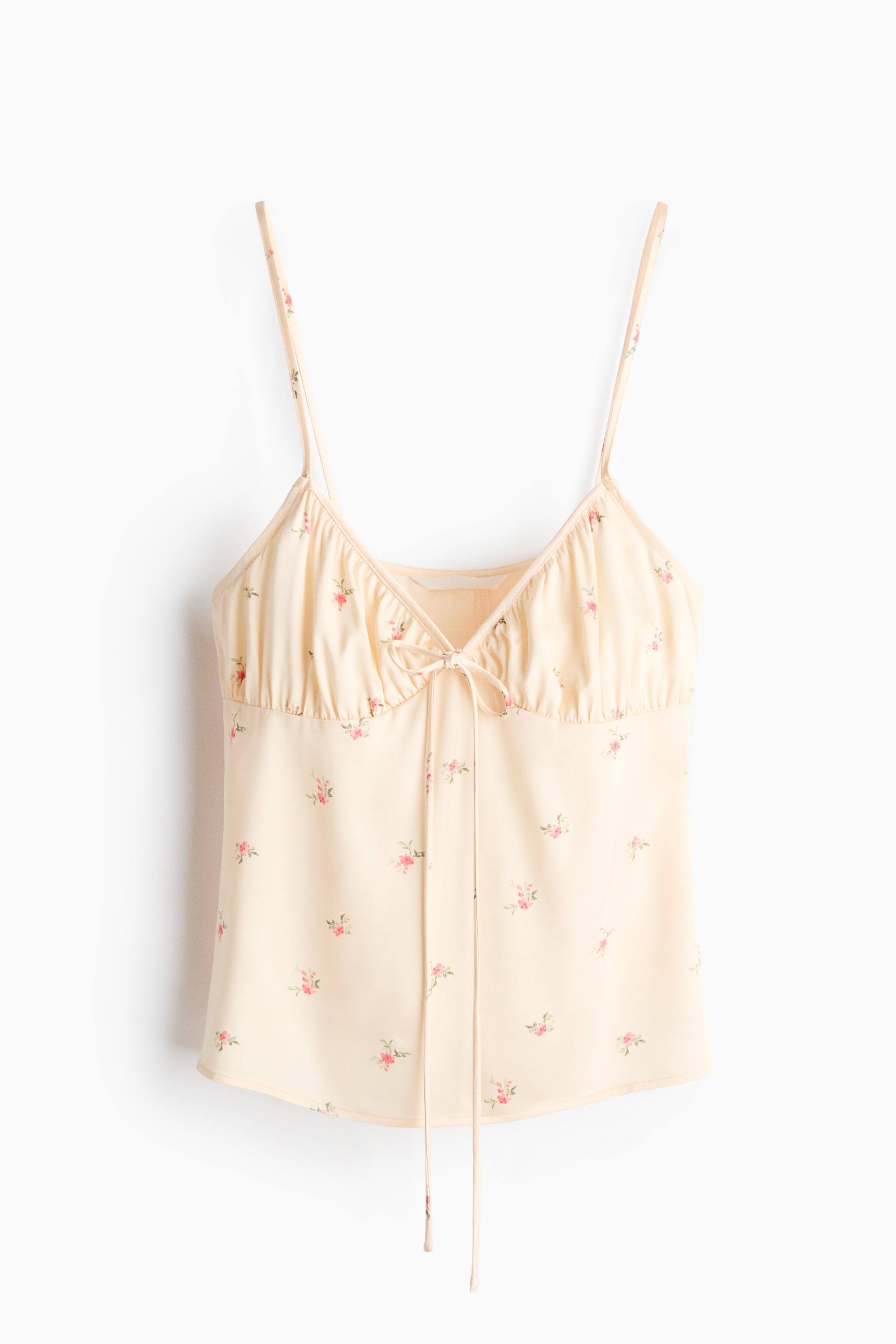 View larger image: A pale yellow camisole top showcases a scattered pink floral print. It's crafted with thin spaghetti straps, a V-neck, and a ruched bust featuring a tie-front detail at the centre.