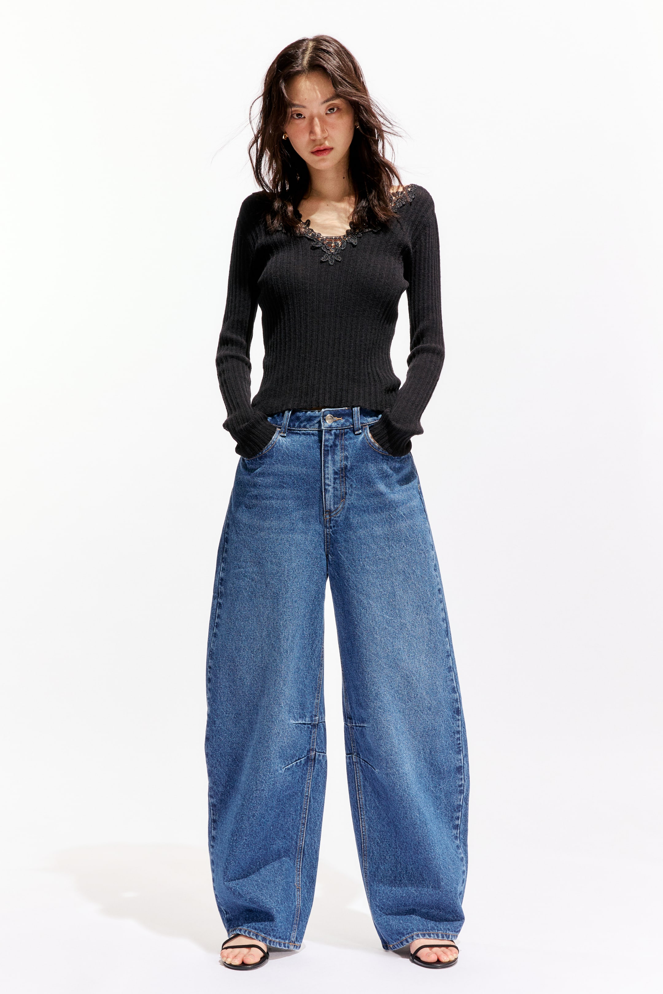 이미지 확대 보기: 모델이 착용한 5-포켓 진은 견고한 면 데님으로 제작되었으며, 레귤러 허리선, 지퍼 플라이, 버튼이 특징입니다. 이 진은 배럴 레그와 눈에 띄는 무릎 다트가 있는 릴랙스 핏으로, 모델은 앞주머니에 손을 넣고 있습니다.