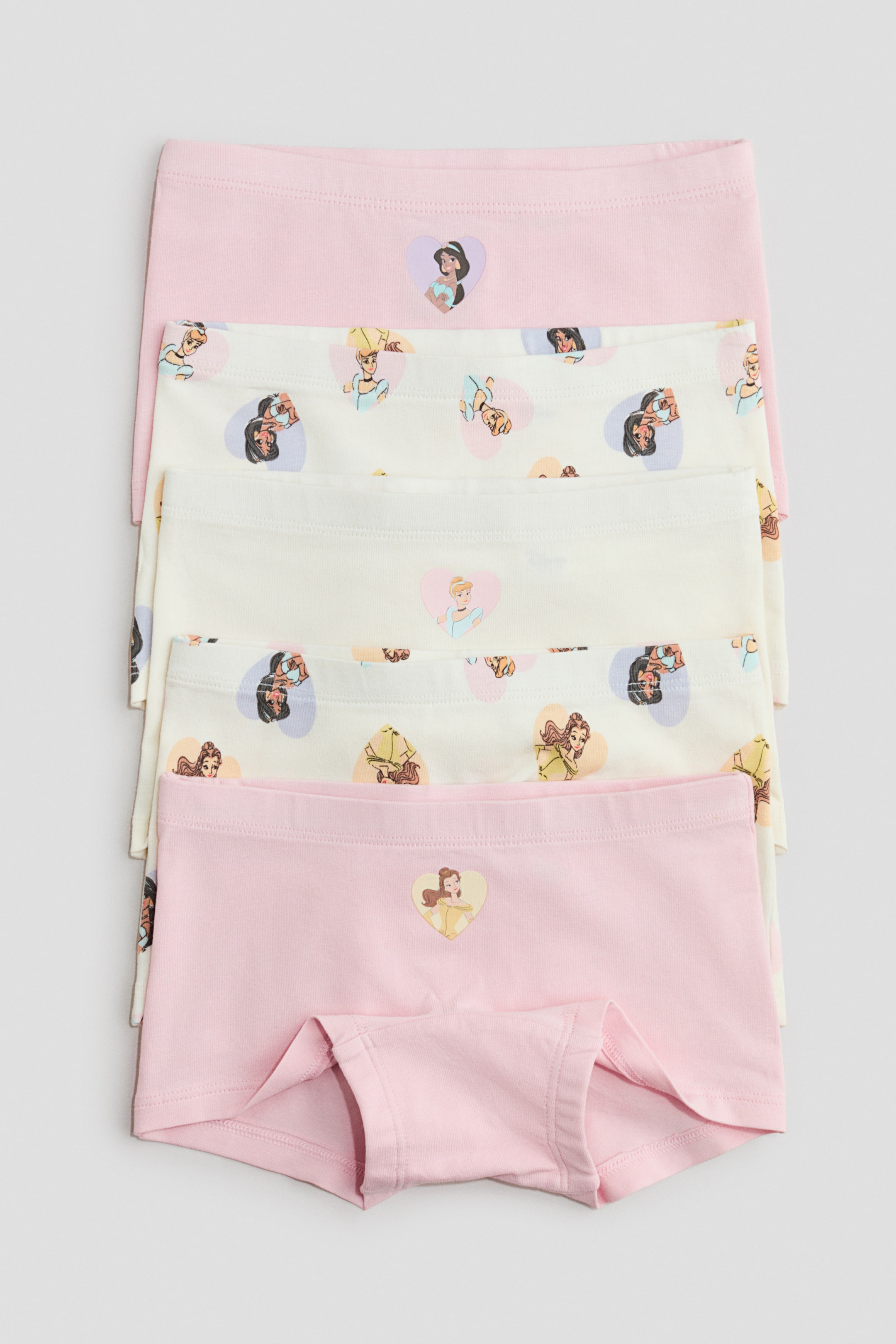 Visa större bild: Flera boxerkalsonger är staplade och visar deras FRAMSIDES vy. De har elastiska midjeband och tryckt bomullsjersey med animerade kvinnliga karaktärer i hjärtform, där den nedersta rosa kalsongen visar sin grenkil.