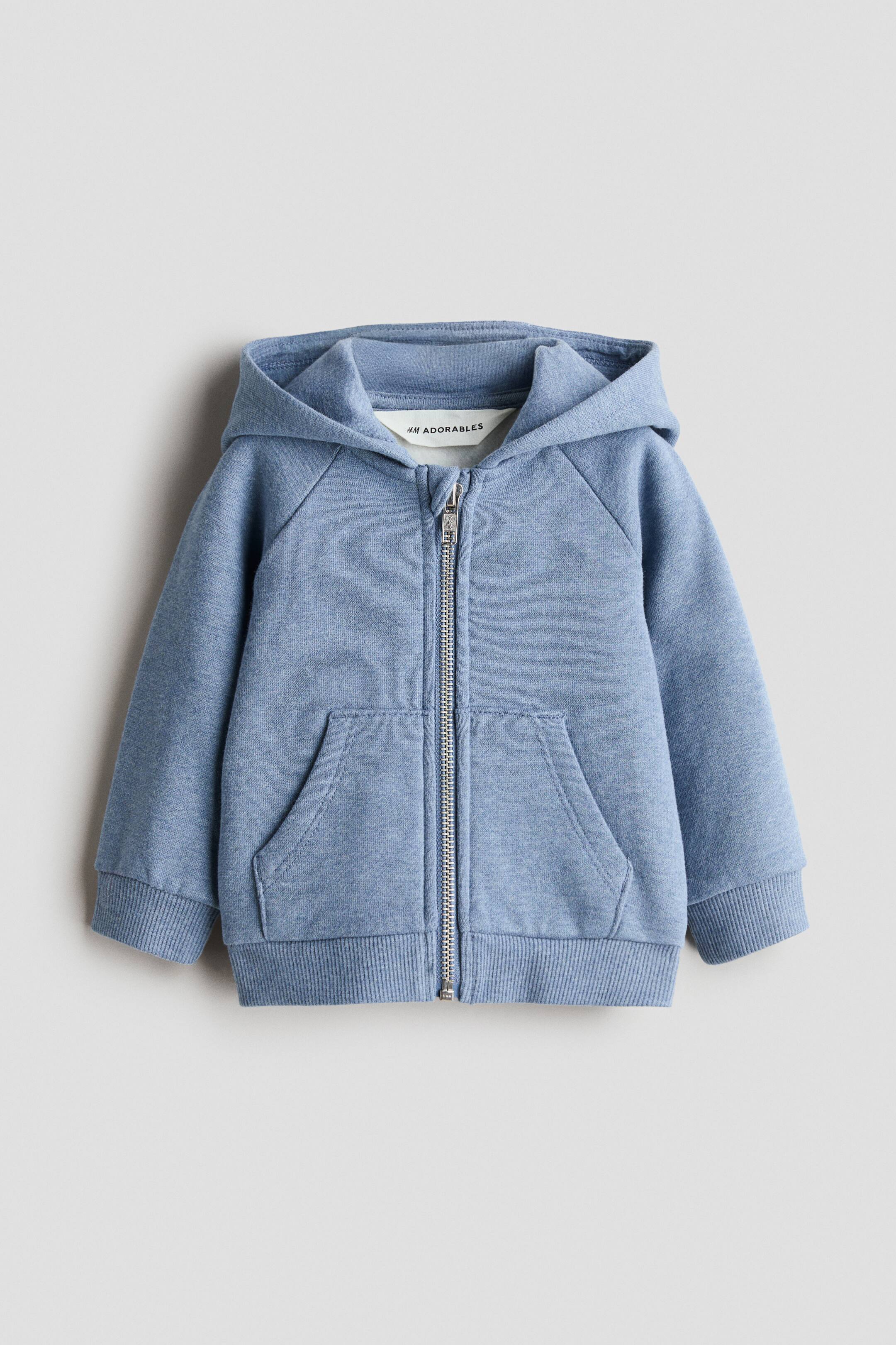 View larger image: A light blue H&M Adorables zip-through hoodie is shown from the front, featuring a lined hood with a visible 'H&M Adorables' tag, a silver-toned zipper down the front, two front pockets, raglan sleeves, and ribbed cuffs and hem.