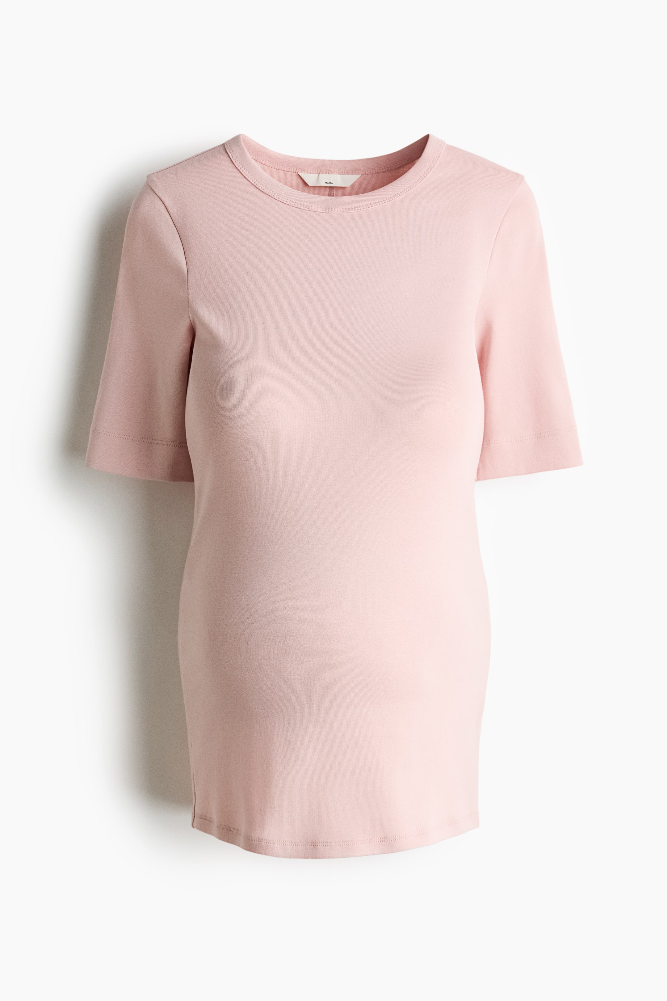 View larger image: A pale pink short-sleeved top, shown from the front, featuring a ribbed crew neck, cuffed sleeves, a relaxed fit with a curved silhouette and side slits at the hem.