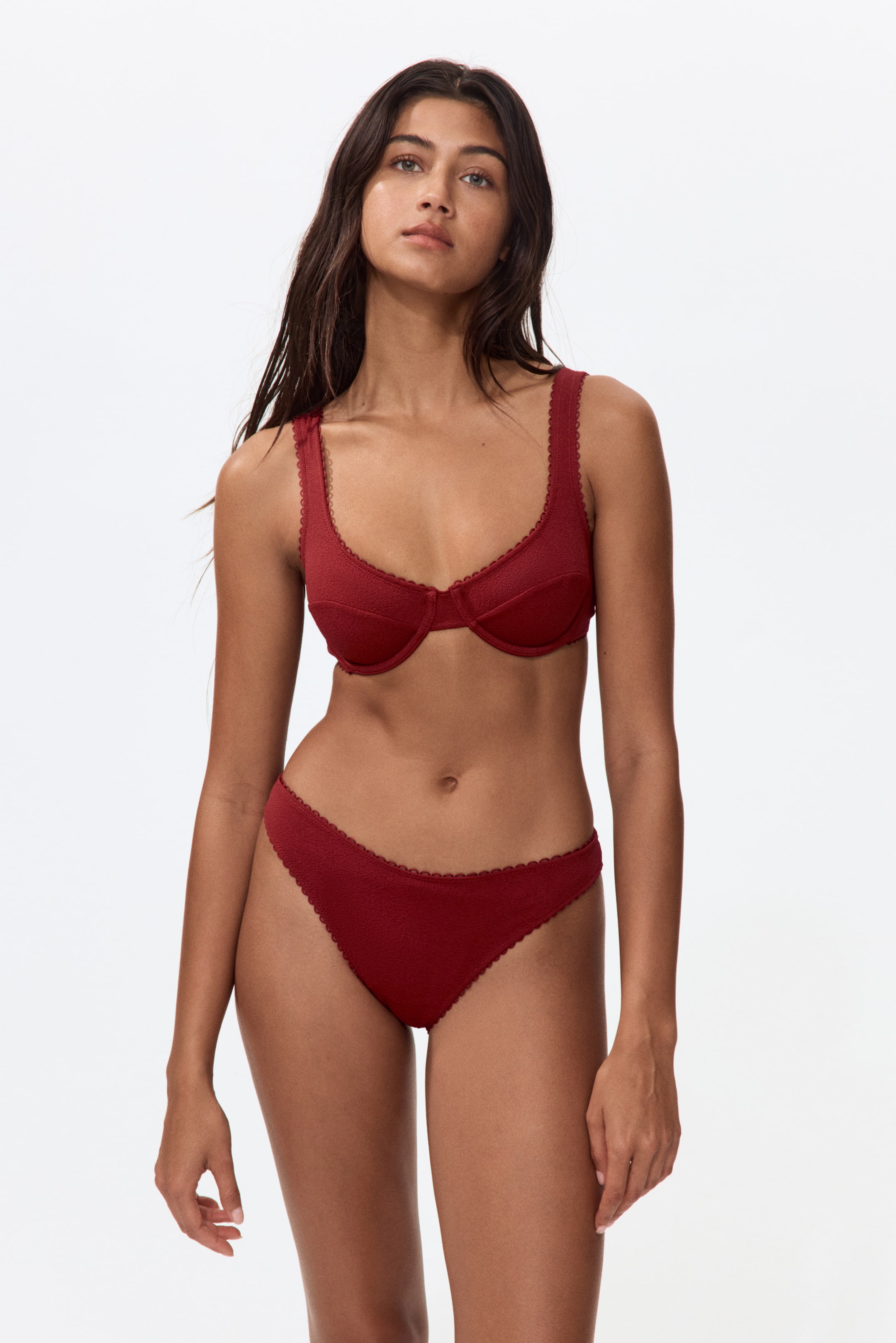 Visualizza l'immagine ingrandita: Un top bikini rosso presenta coppe con ferretto che modellano il busto in modo naturale. È progettato con spalline larghe e rifiniture a picot lungo i bordi delle coppe e delle spalline.