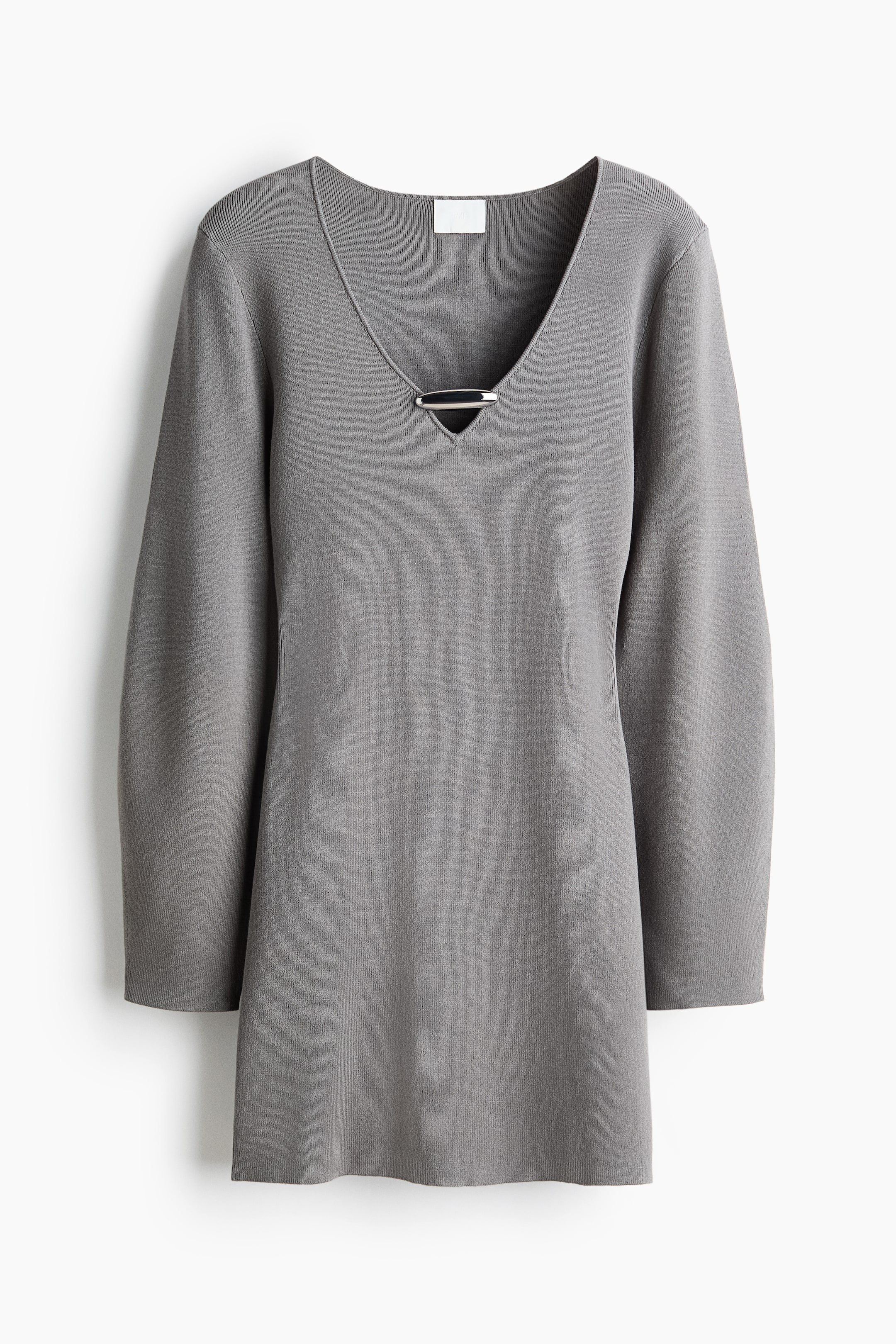 View larger image: This grey knit mini dress is shown from the front, featuring a deep V-neckline accented by a horizontal, silver-toned metal bar. The dress features long, slightly relaxed sleeves and a straight-cut silhouette in a fine knit texture.