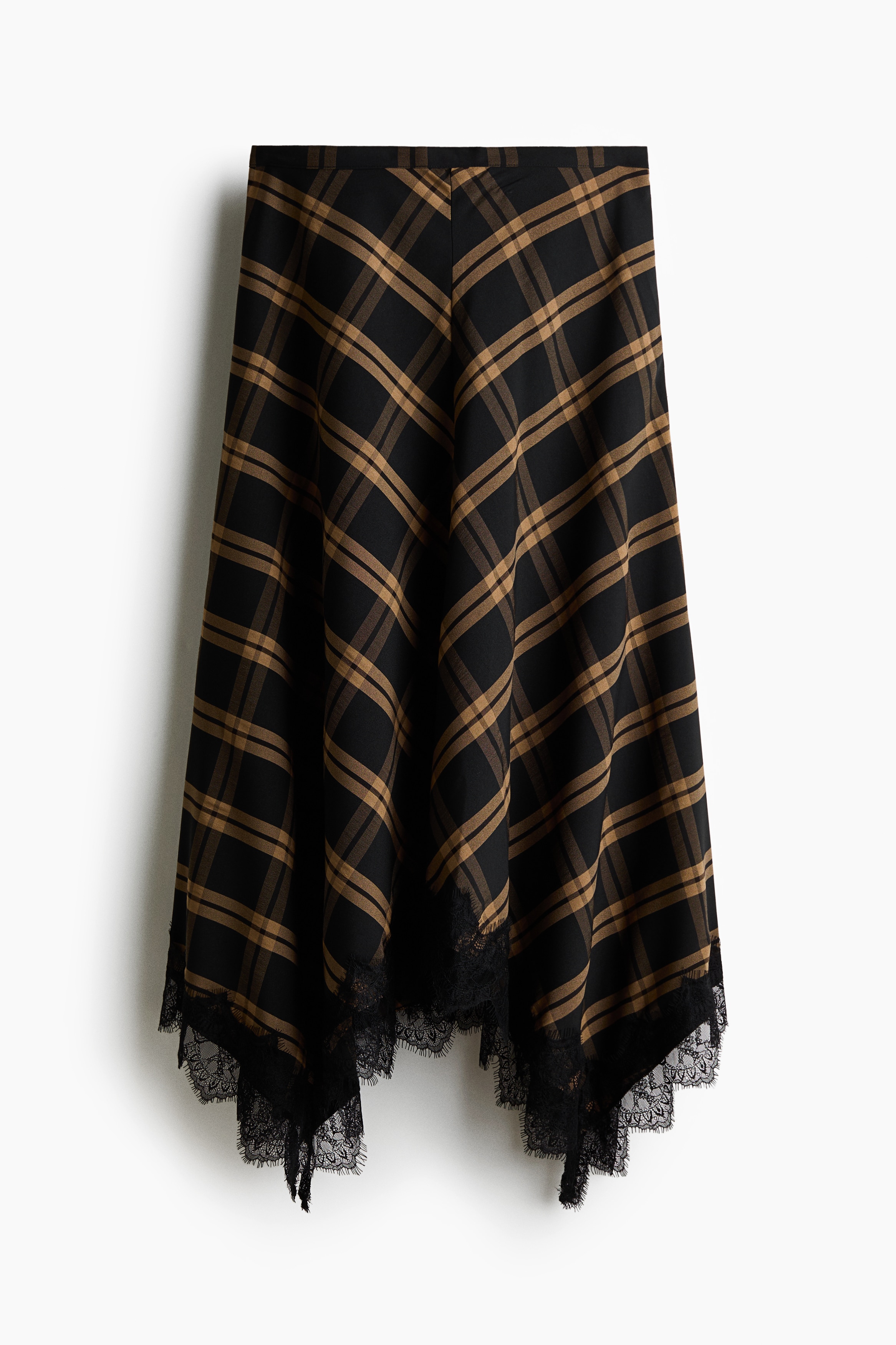 A loose-fit maxi skirt in a brown and black plaid pattern is being worn by the model, featuring a handkerchief hem finished with black lace trim. The skirt is styled with a matching sleeveless plaid top and flat black sandals.