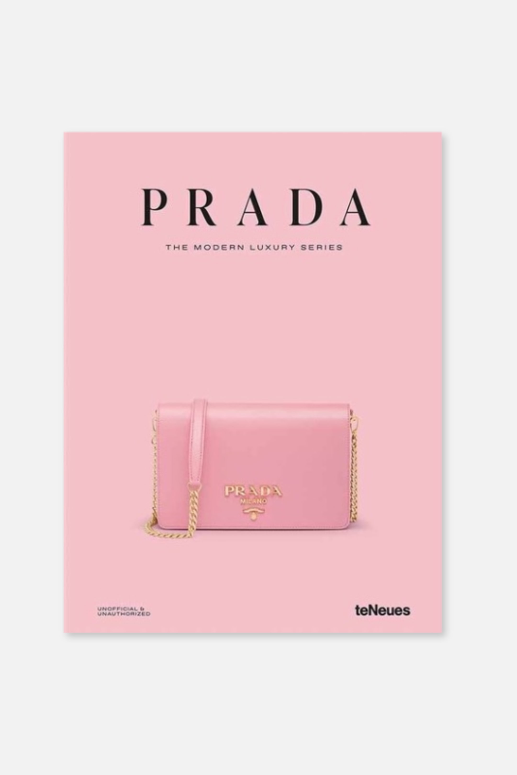 Agrandir l'image: Un livre rose intitulé "Prada The Modern Luxury Series" présente sa couverture avant, qui arbore un sac à main rose avec une bandoulière en chaîne dorée et un logo "Prada Milano" doré.