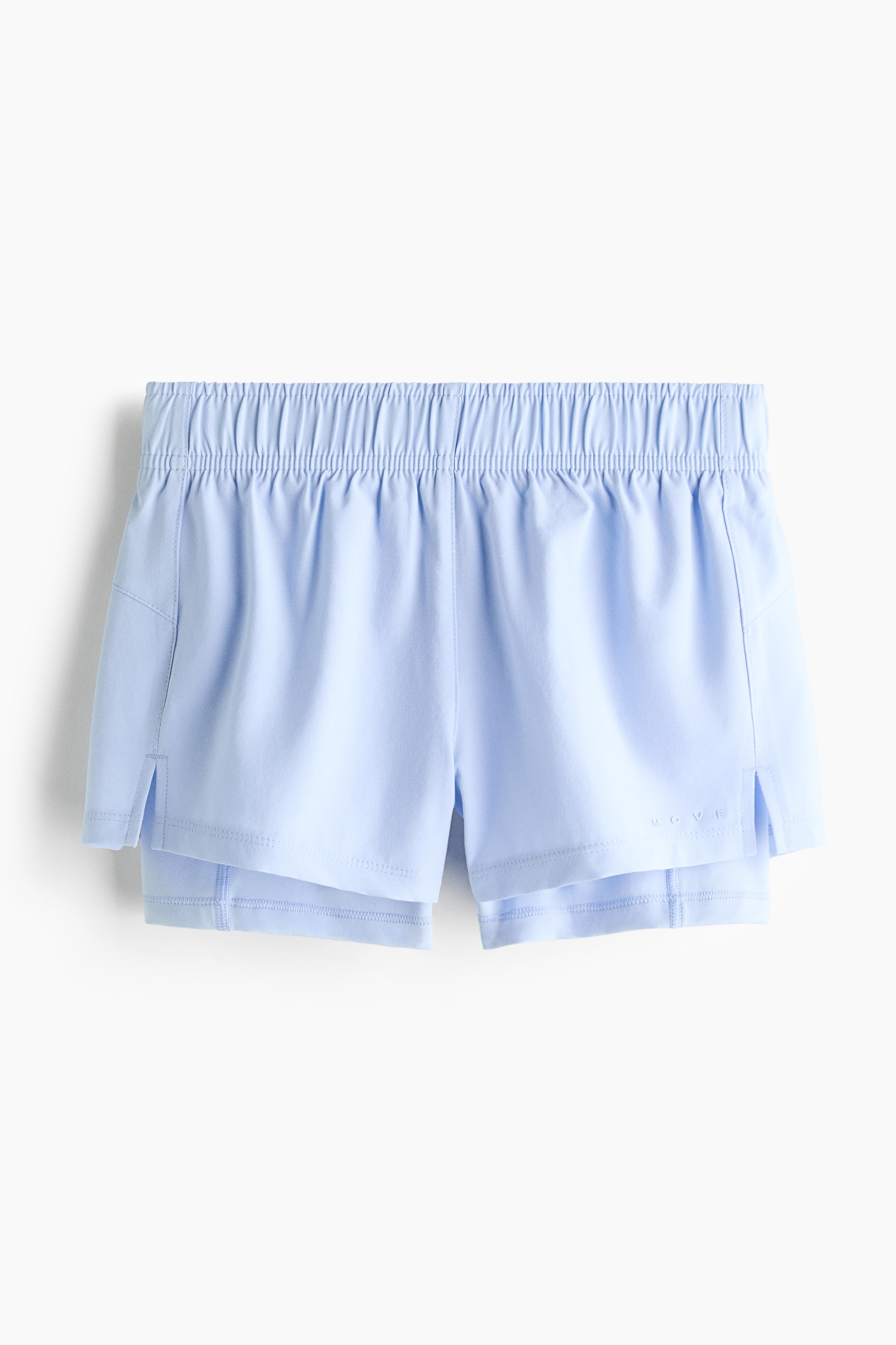 View larger image: Double-layered running shorts are showcased from the front in a light blue hue, featuring an elastic, ruched waistband. A relaxed outer layer displays small side slits and a 'MOVE' logo on the lower right leg, layered over a slightly longer, fitted inner layer.
