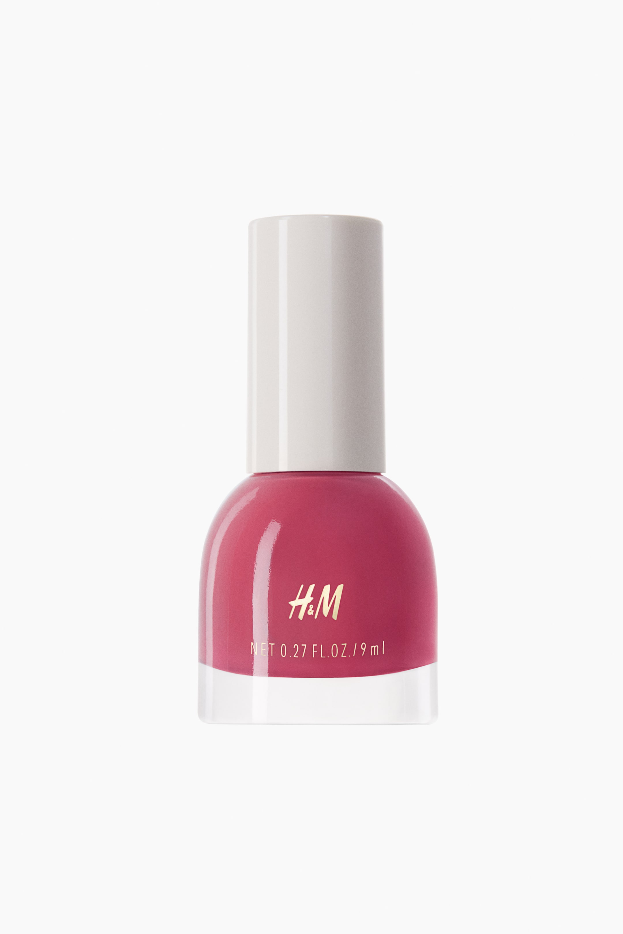 View larger image: A nail polish bottle is standing front-facing, featuring a deep pink polish. The clear glass bottle has a rounded pink body displaying "H&M" and "NET 0.27 FL. OZ. / 9 ml" in gold text, and is topped with a white cylindrical cap.