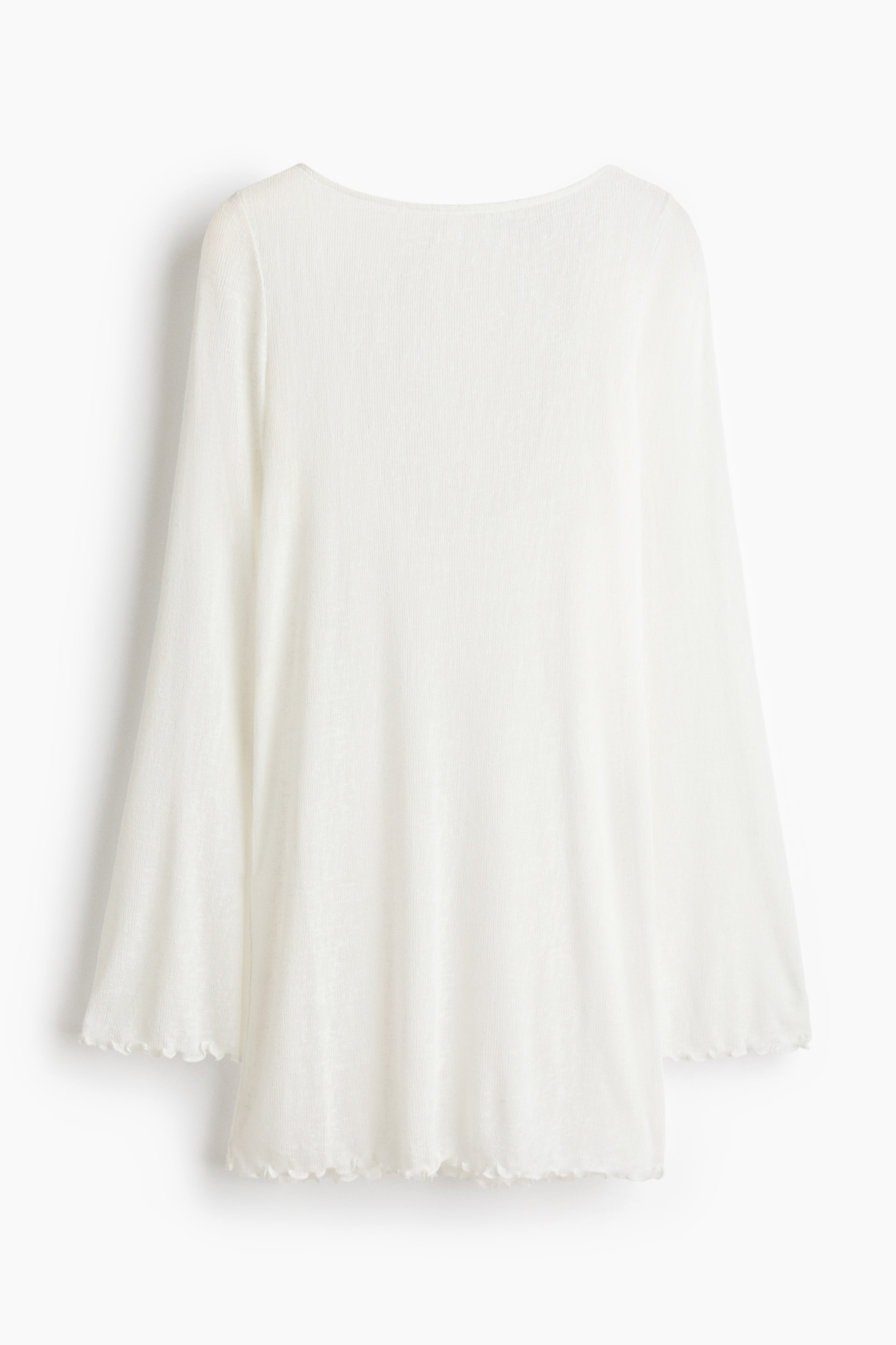 View larger image: The back view of a white mini beach dress showcases its sheer jersey fabric, scoop back, long flared sleeves, and overlocked edges finishing the cuffs and hem.
