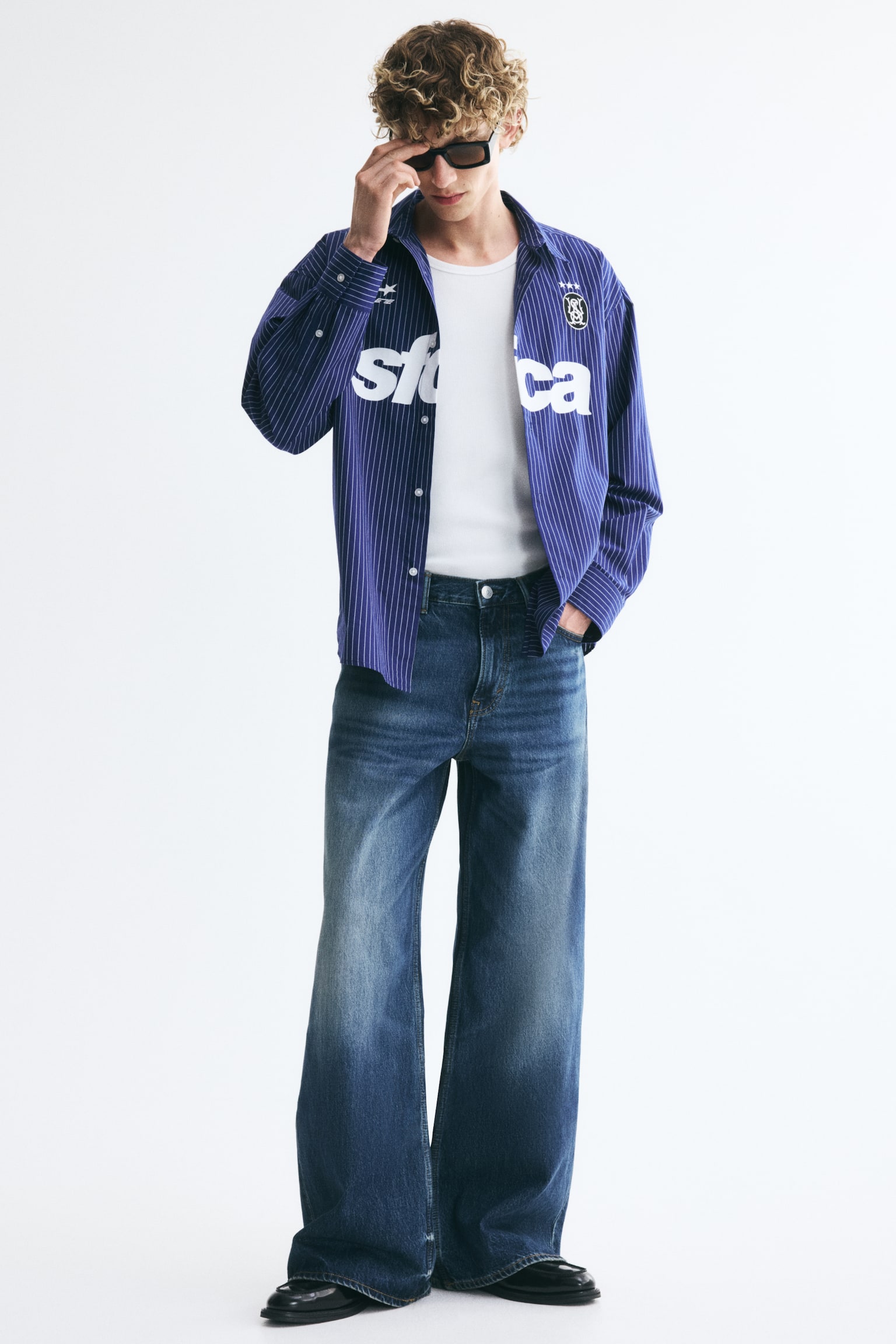 Dark blue wide-leg jeans are showcasing a front view, boasting a high waist, two curved front pockets with a coin pocket, and faded distressed details on the thighs and pocket edges. - 1
