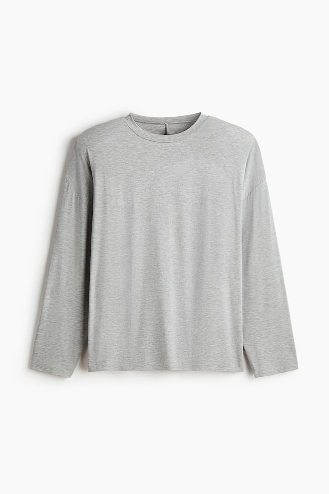 The front view of a grey long-sleeved shirt is displayed, showcasing a crew neck, long sleeves, and a heathered texture. - 1