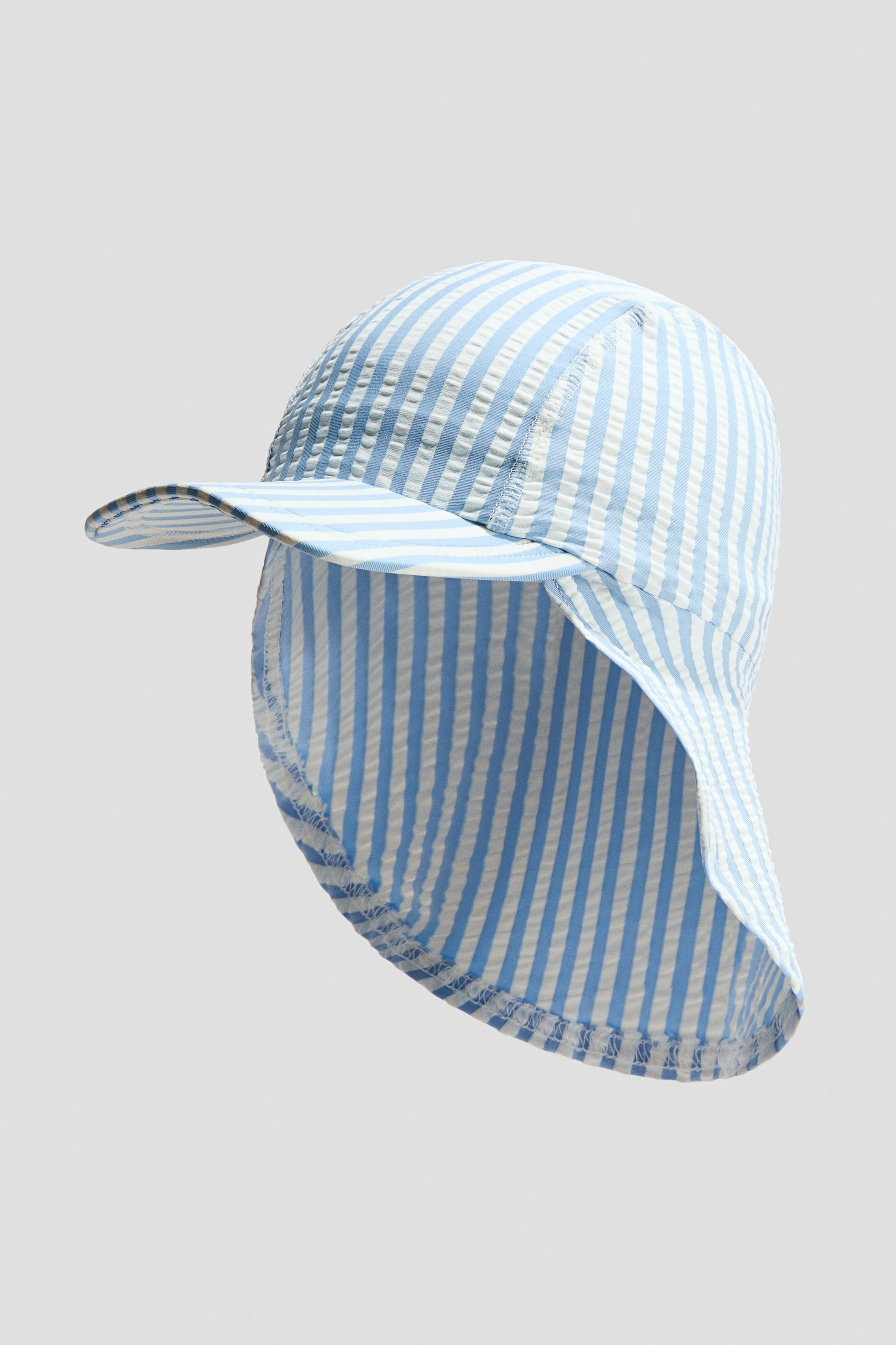 View larger image: This sun hat showcases blue and white vertical seersucker stripes. It highlights a curved front brim and a long neck flap extending from the back.