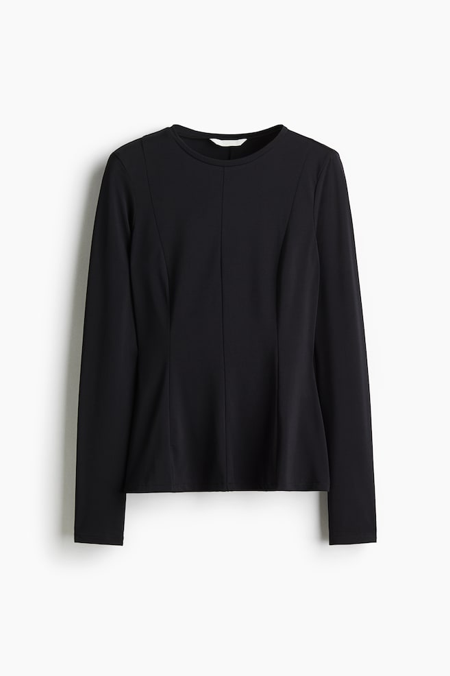 Czarna bluzka peplum jest skierowana do przodu, z okrągłym dekoltem i długimi rękawami. Pionowe szwy modelujące biegną od ramion, tworząc dopasowaną sylwetkę, która rozszerza się od talii do dołu. - 1