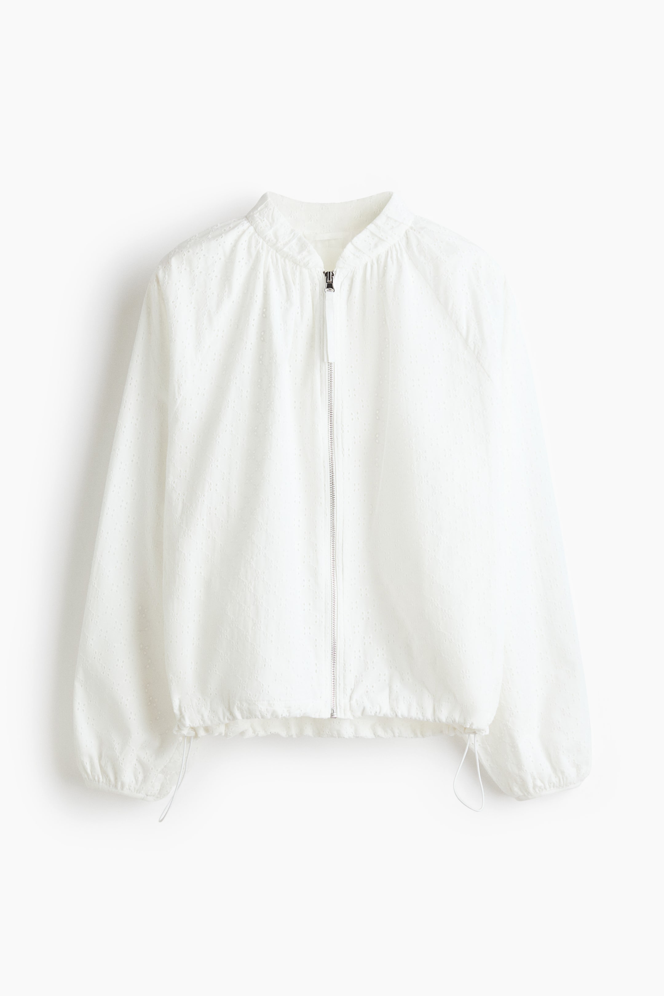 View larger image: A white bomber jacket is shown from the front, featuring a delicate eyelet pattern throughout and a silver-toned full-zip closure. It showcases a gathered stand-up collar, long raglan sleeves, and an elasticized hem with visible drawstrings.