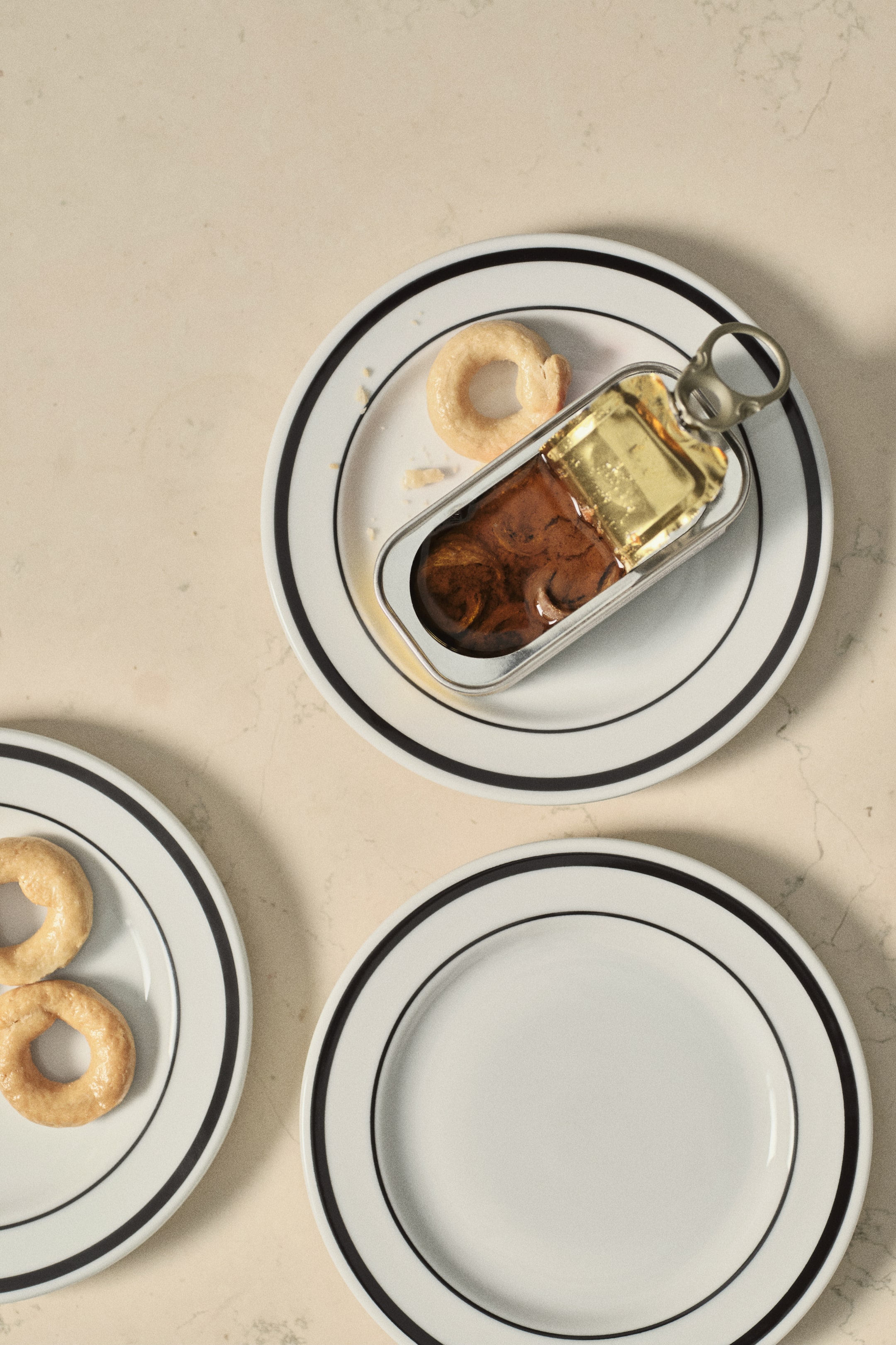 View larger image: The side plates are displayed from a top-down perspective. Each white porcelain plate features a classic painted rim with two concentric black lines.