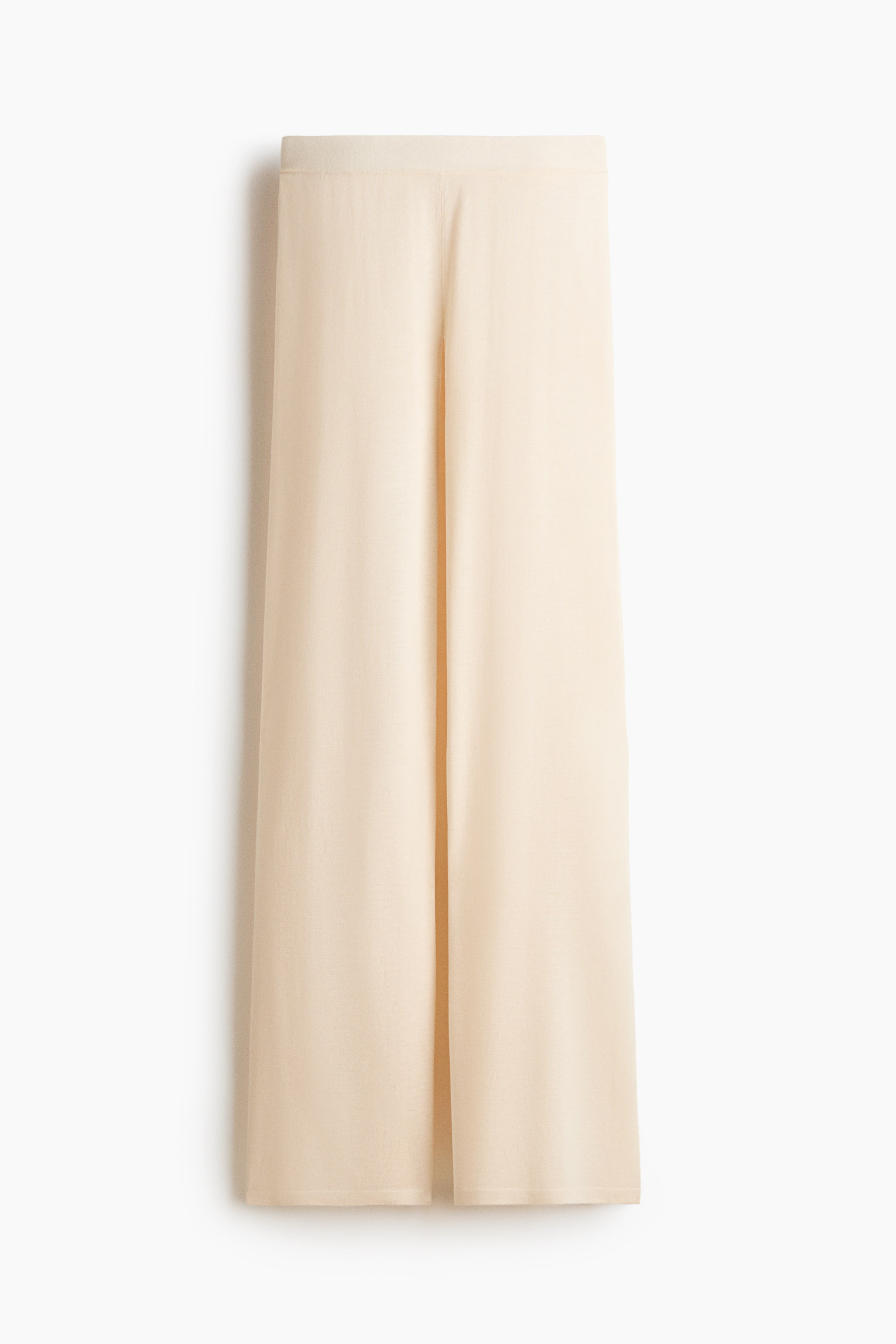 Agrandir l'image: Un pantalon beige clair à jambes larges est posé à plat, face avant visible, avec une ceinture lisse et plate et des jambes droites ornées d'un pli vertical central sur chaque jambe.