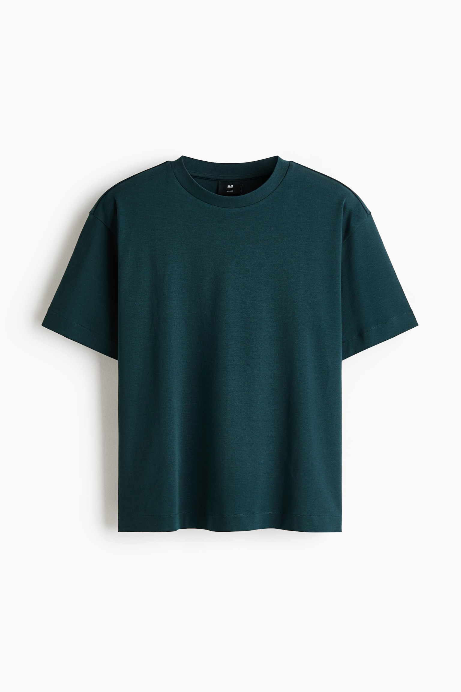 ダークティールのTシャツが正面から示されています。ルーズでボクシーなフィット感が特徴で、ラウンド型のリブトリム付きネックライン、ドロップショルダー、ストレートカットの裾が施されています。 - 1