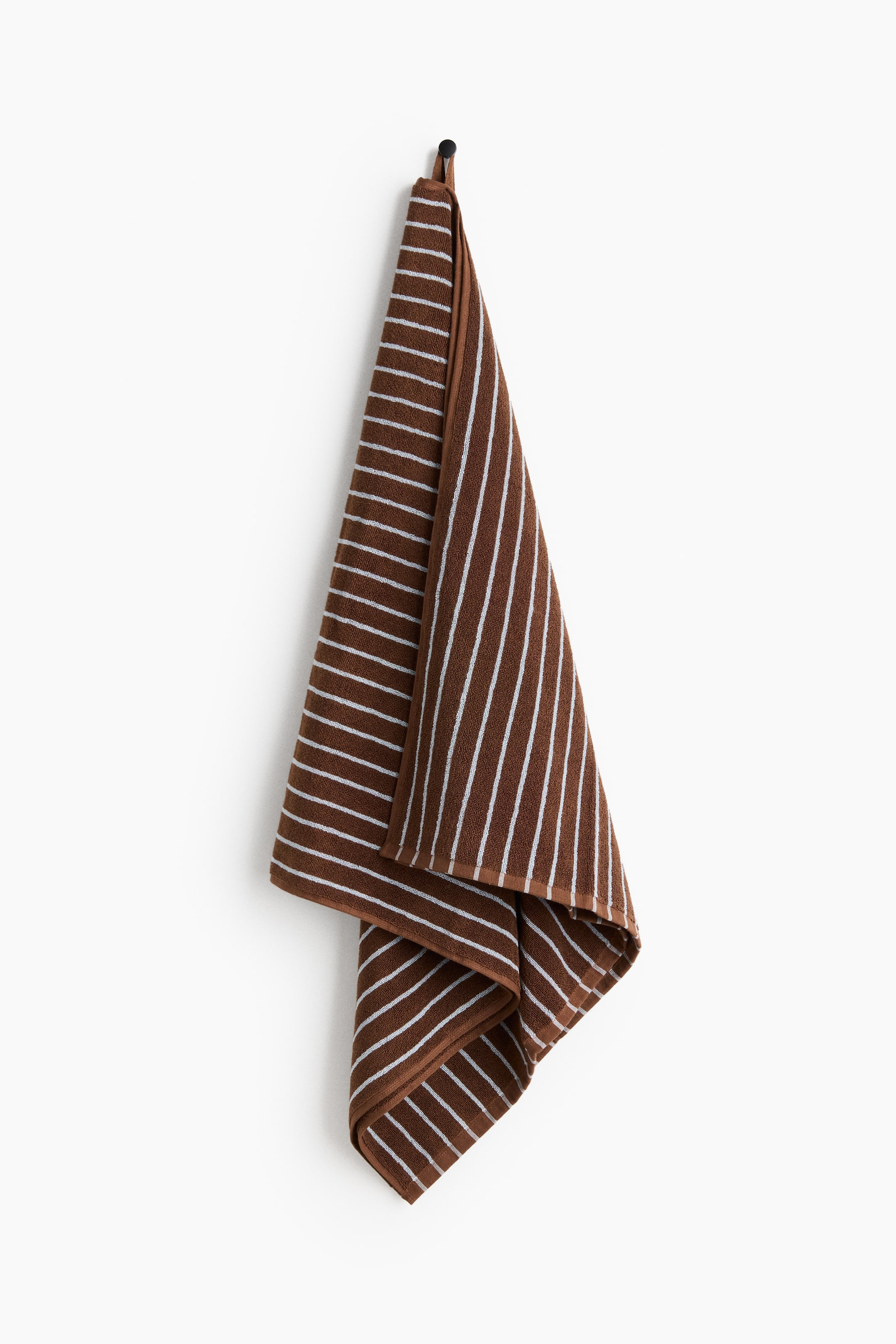View larger image: A brown cotton terry bath towel, shown from the front, hangs from a hook. It features white yarn-dyed stripes, and a loop is visible at the top for hanging.