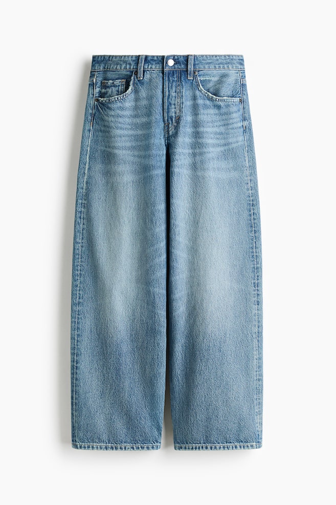 A pair of wide-leg jeans in a faded medium blue wash is facing front, showcasing a relaxed, straight silhouette with prominent fading down the center of each leg. The jeans are featuring classic five-pocket styling, belt loops, and light whiskering at the hips. - 1