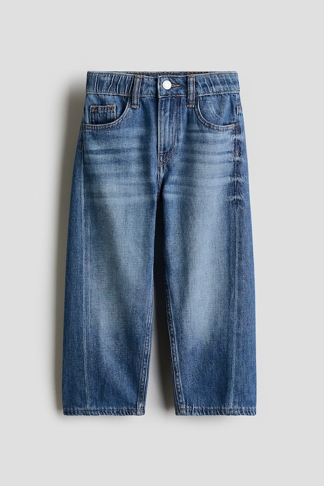The FRONT of 5-pocket jeans in medium blue cotton denim is being displayed, featuring a loose fit through the hip and thigh with barrel legs. They are designed with an adjustable elasticated waist, a zip fly with a press-stud, and curved side seams running down the legs. - 1