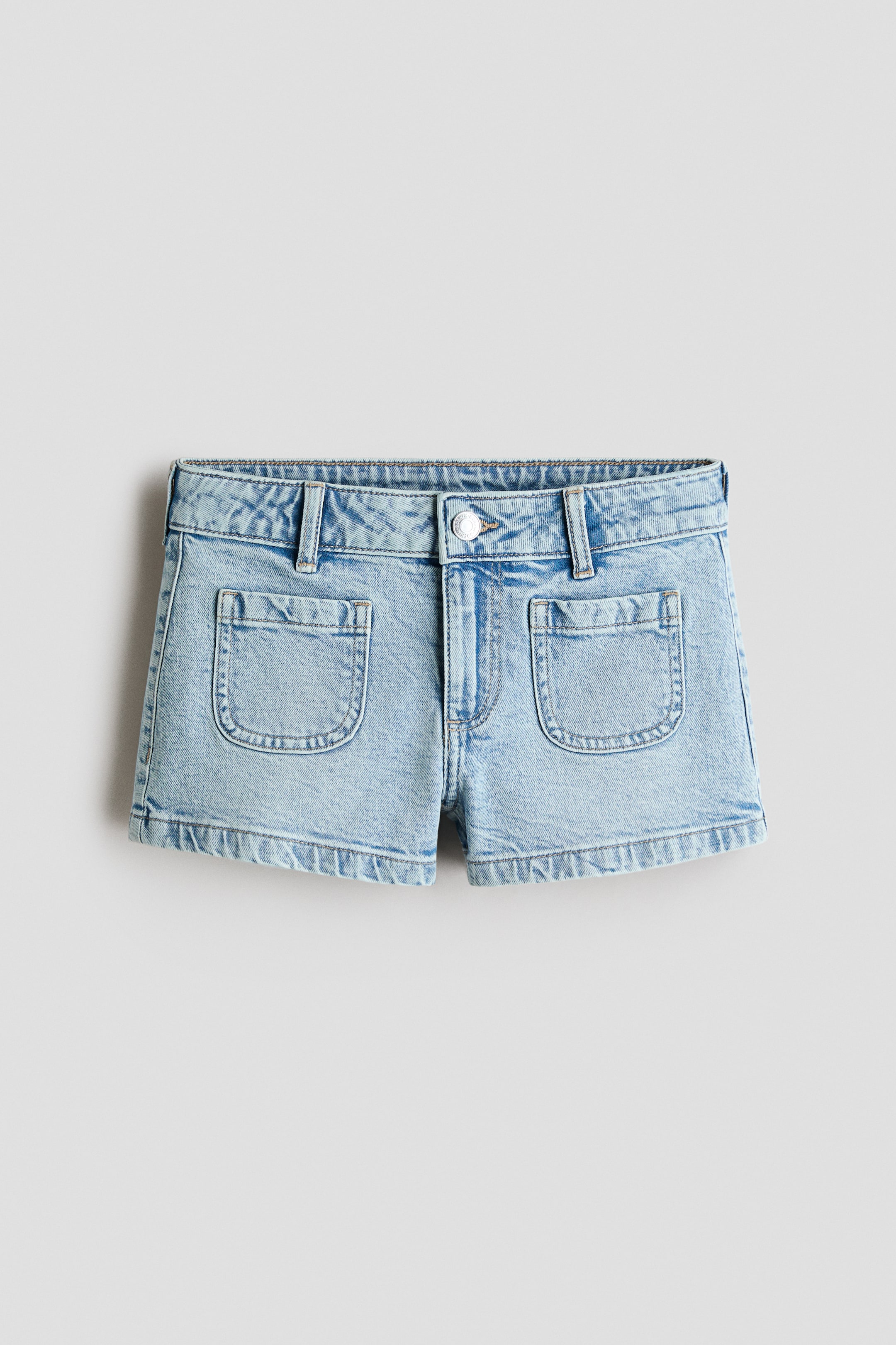 Agrandir l'image: Short en denim de coton bleu clair à coupe décontractée présenté en vue de face. Il est doté d'une fermeture à bouton et zip, d'une taille avec passants pour ceinture, et de deux poches plaquées arrondies à l'avant.
