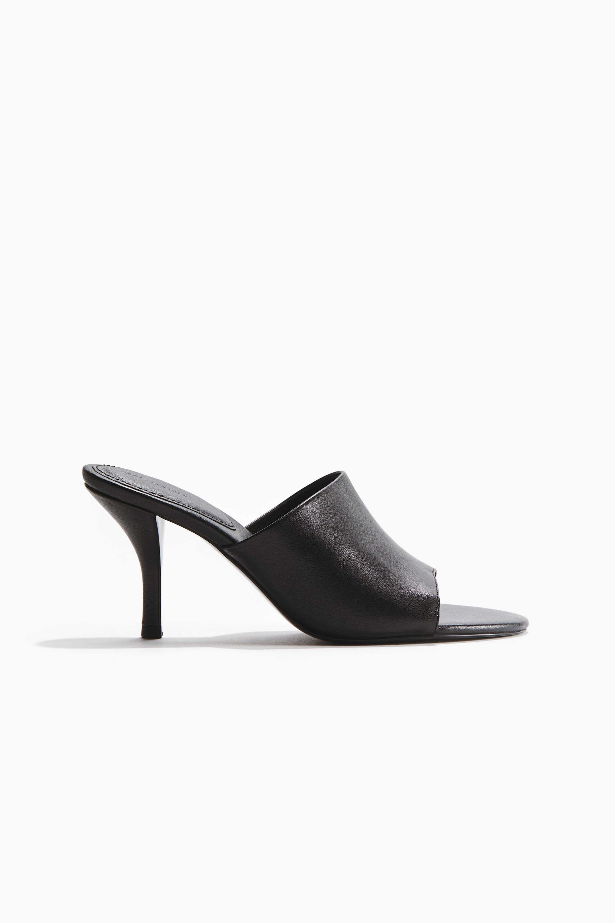 View larger image: A black leather sandal featuring an oblique toe, a wide foot strap, and a narrow, partially covered heel.