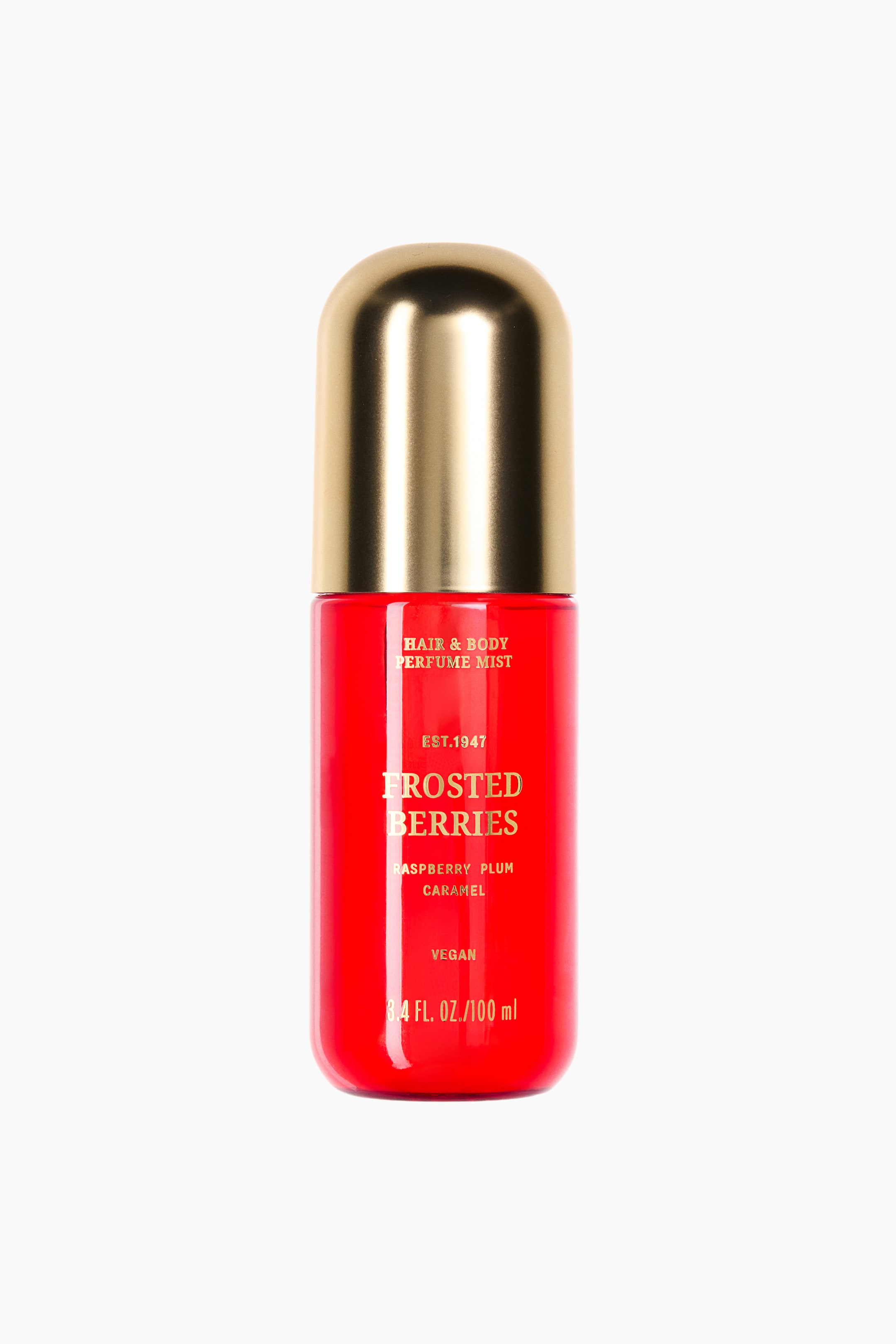 Ampliar la imagen: Un frasco de bruma perfumada para cabello y cuerpo se encuentra al frente, con una base cilíndrica roja vibrante y una tapa redondeada dorada brillante. En la parte frontal del frasco se muestra texto en dorado, que incluye "FROSTED BERRIES", "RASPBERRY PLUM CARAMEL", "VEGAN" y "3.4 FL. OZ./100 ml."