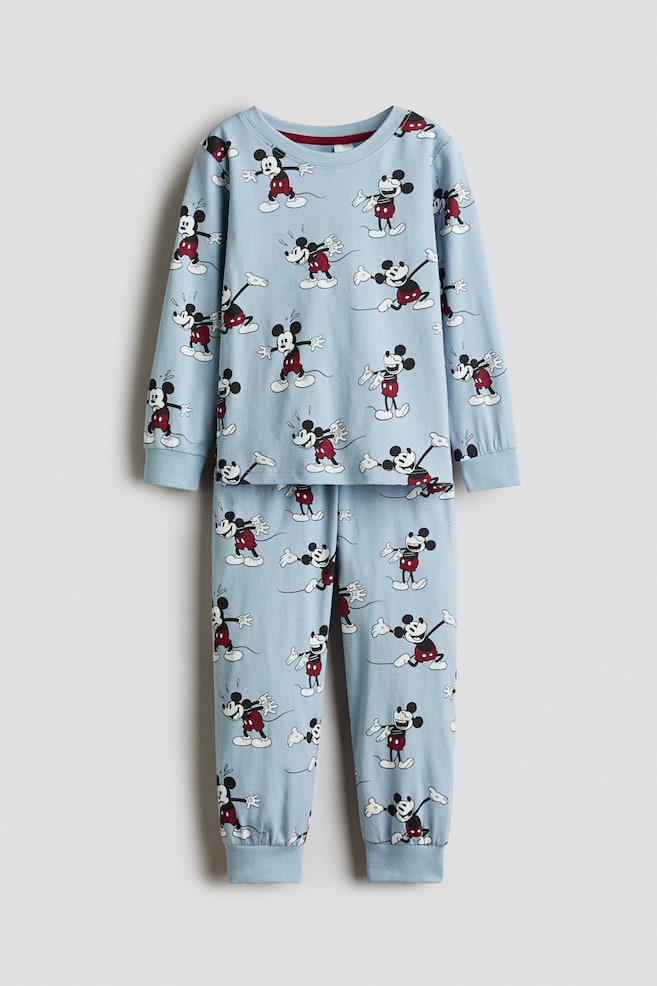 Ein hellblaues Pyjama-Set aus Baumwolljersey in Frontansicht mit einem allover Mickey-Mouse-Print. Das langÃ¤rmlige Oberteil verfÃ¼gt Ã¼ber einen runden, gerippten Halsausschnitt und gerippte BÃ¼ndchen, wÃ¤hrend die passende Hose an den KnÃ¶cheln gerippte BÃ¼ndchen zeigt. - 1