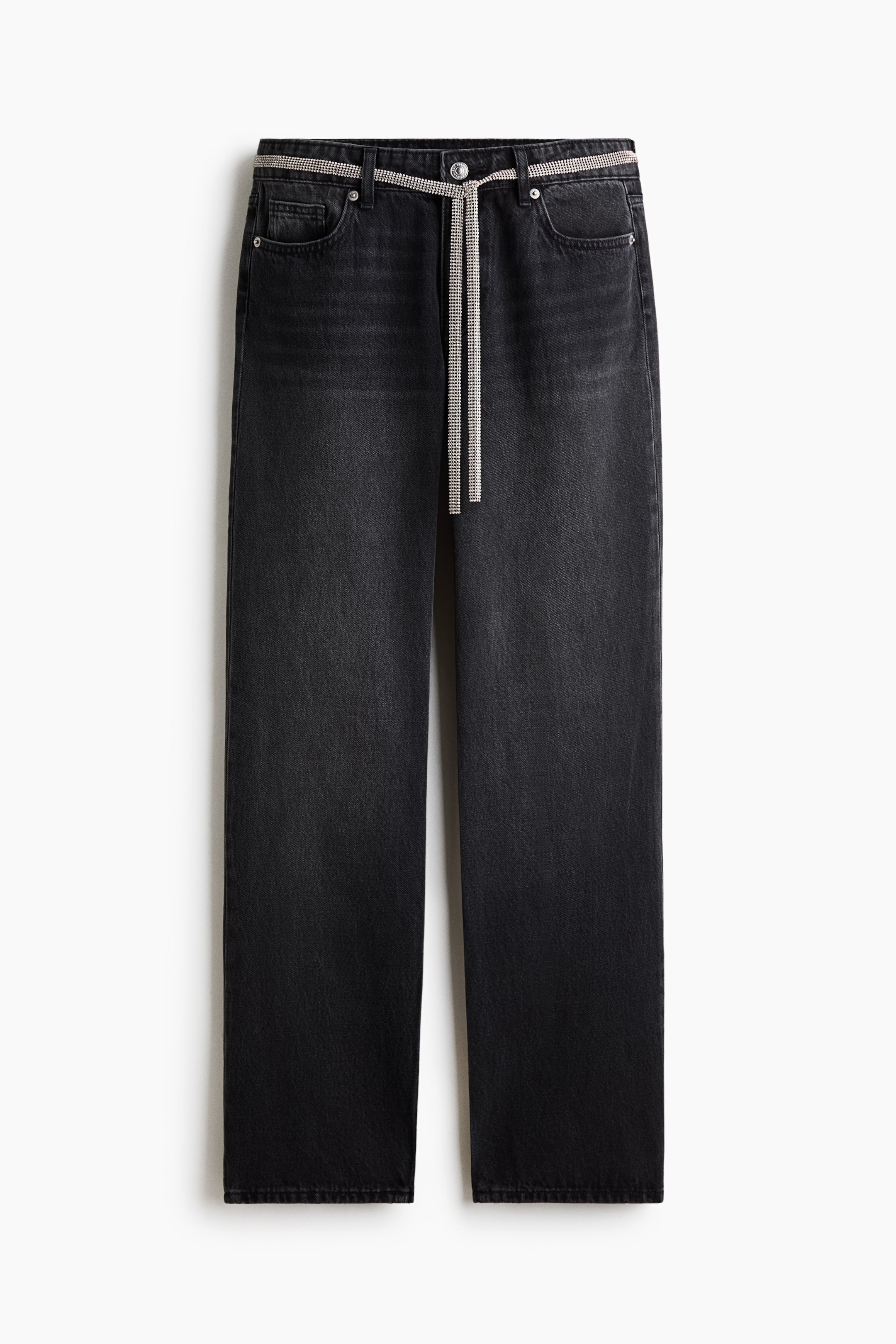 Voir une image plus grande: Une paire de jeans en denim gris foncé à jambe droite est présentée de face, avec une taille régulière, une fermeture à bouton et une ceinture à nouer en chaîne de strass scintillante, passée dans les passants de ceinture.