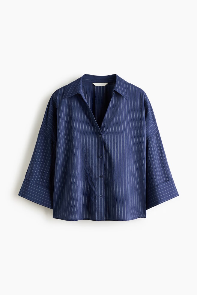A navy blue pinstriped shirt is shown in a laid-back, front-facing view. It features a spread collar with a V-neck opening, a button-front placket with dark buttons, and wide three-quarter length sleeves with cuffs. - 1