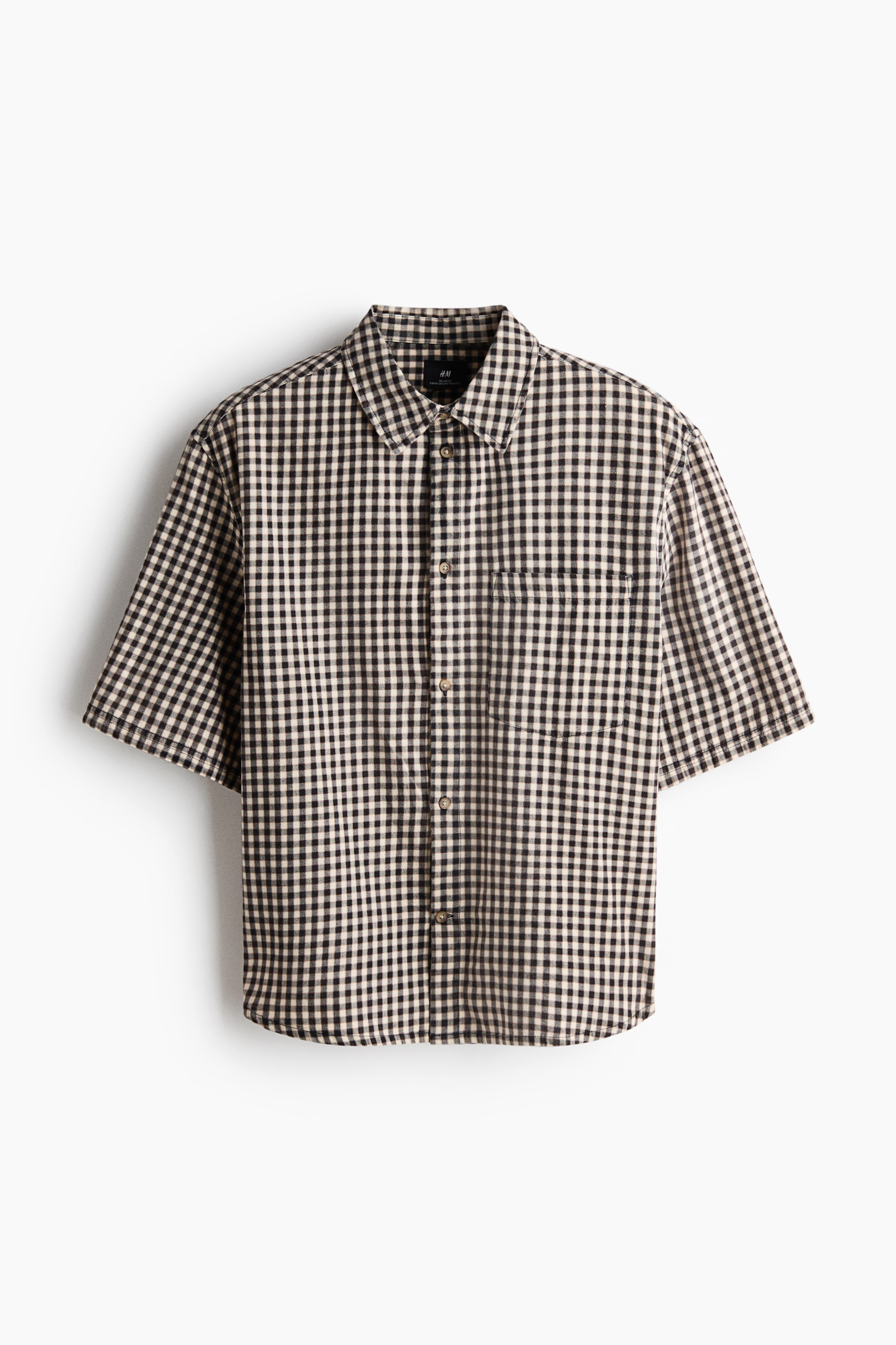 Voir une image plus grande: Une chemise à manches courtes avec boutons présente un motif à carreaux vichy noir et blanc cassé sur le devant. Elle est dotée d'un col pointu, d'une patte de boutonnage complète avec des boutons de couleur claire, et d'une poche plaquée unique sur la poitrine gauche.