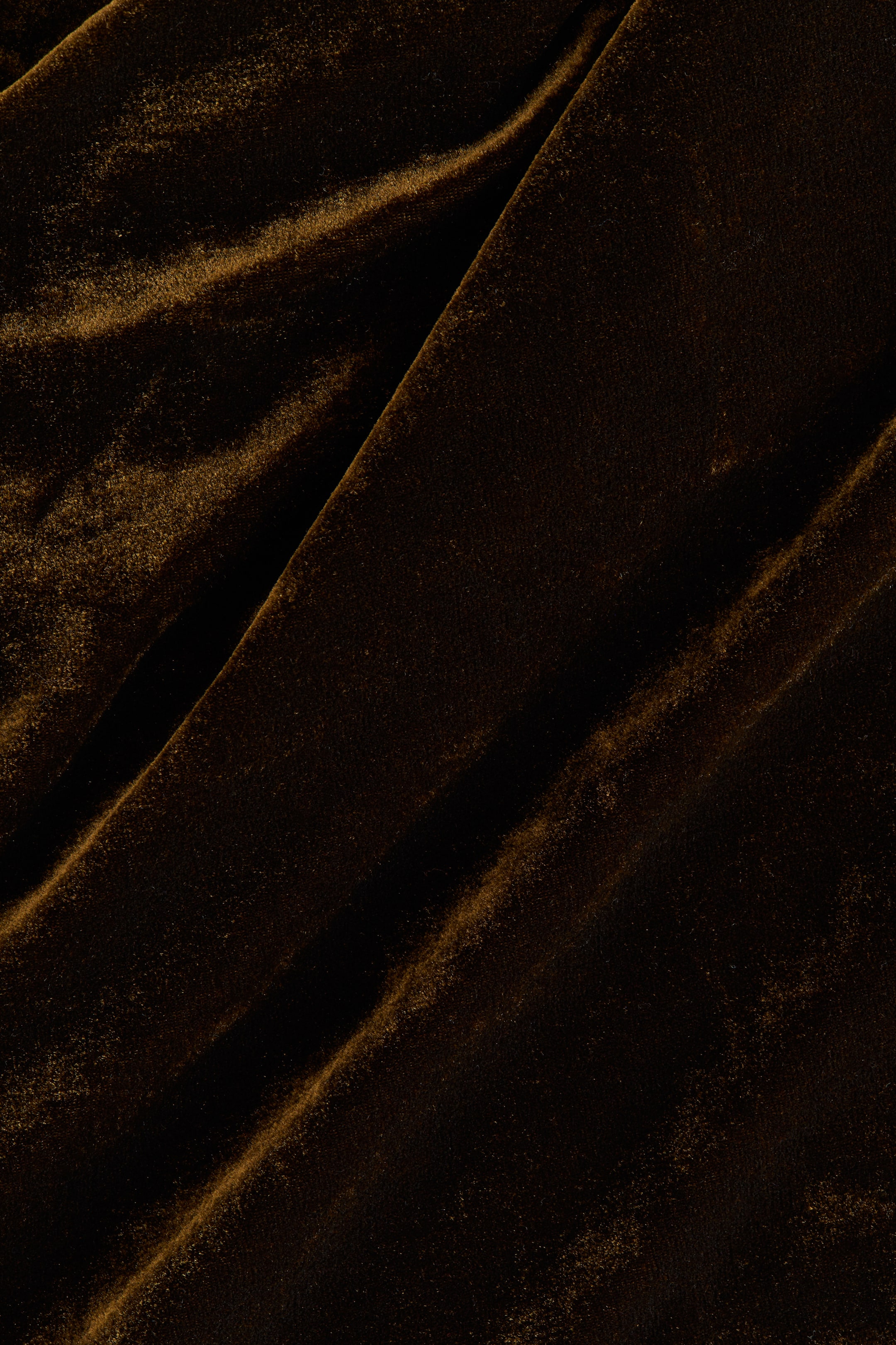 Näytä suurempi kuva: Tummanruskea samettikangas on laskostettu, paljastaen sen pehmeän tekstuurin sekä valon ja varjon leikin sen vaihtelevilla laskoksilla ja rypyillä.