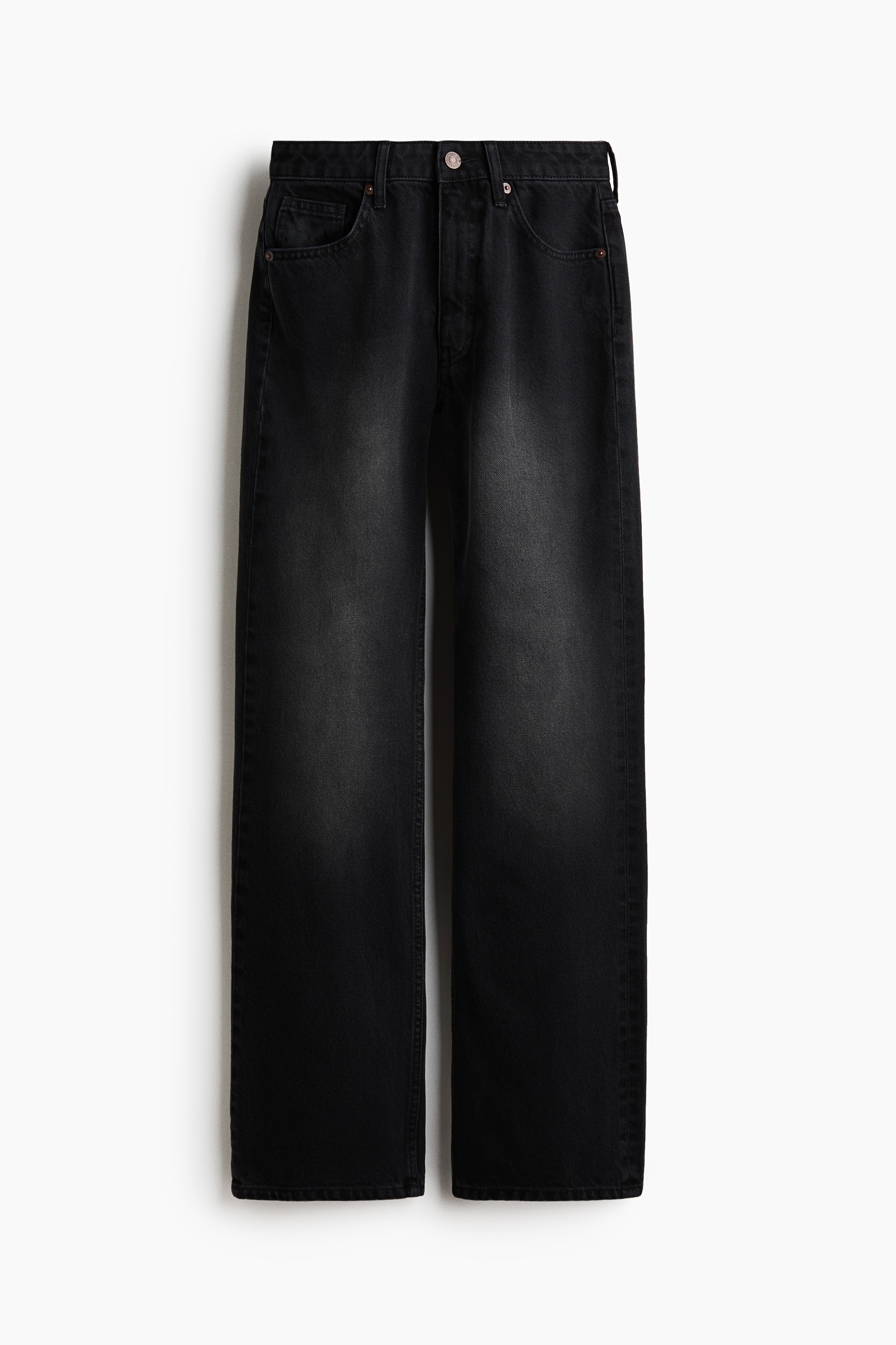 La modelo lleva unos jeans bootcut de lavado oscuro con cintura alta, diseÃ±o de cinco bolsillos y corte ajustado en los muslos que se ensancha hacia el bajo. Los jeans se combinan con un top negro ajustado de doble tirante y sandalias de punta abierta.