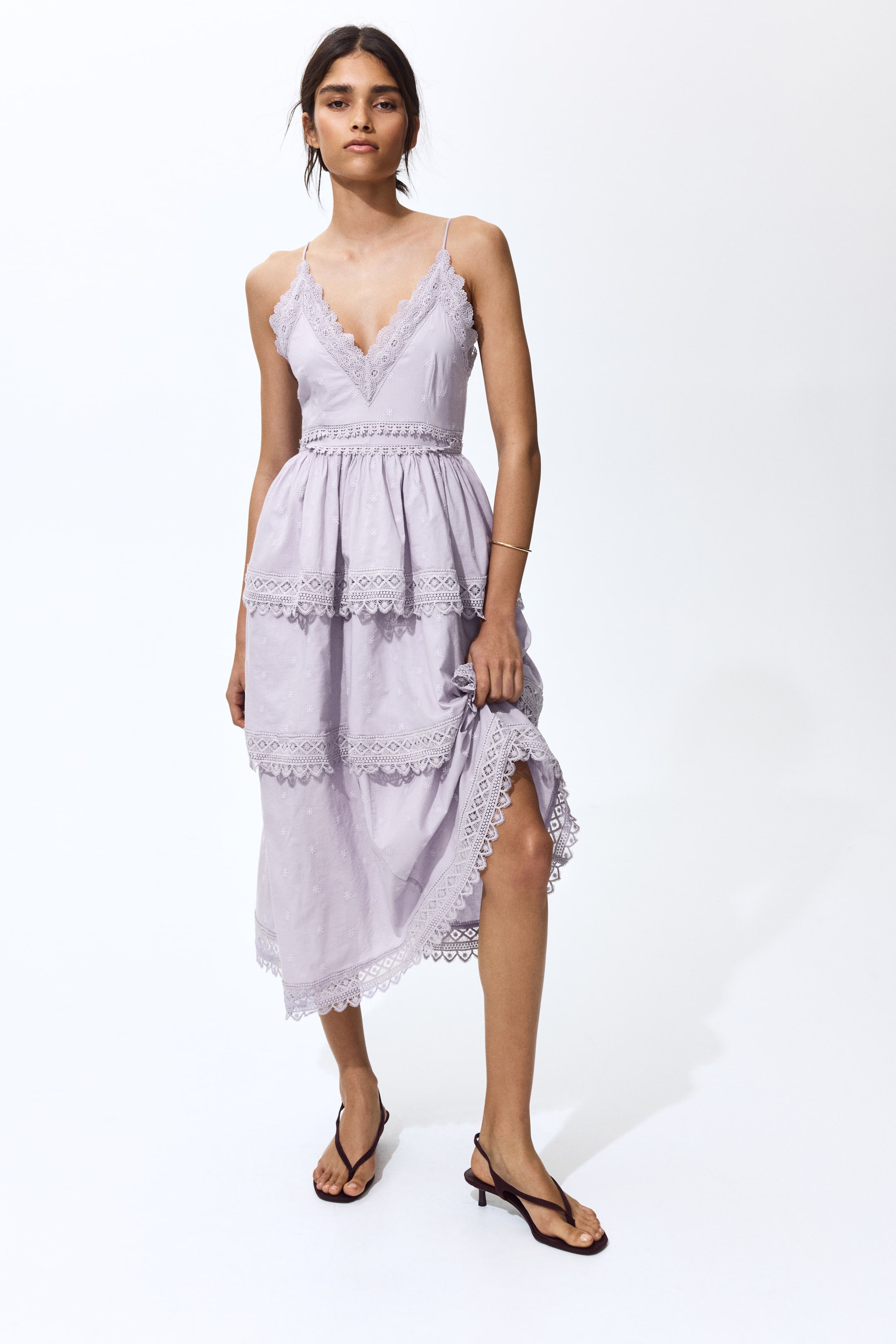 View larger image: Lavender midi dress ini menampilkan leher V dengan trim renda dan tali spaghetti yang halus, mempamerkan garis pinggang yang terdefinisi dengan penggumpulan. Skirt berlapis ini dihiasi dengan renda yang sepadan pada setiap lapisan, dan fabriknya disulam secara halus dengan corak kecil; satu sisi skirt diangkat dengan lembut untuk menonjolkan reka bentuk berlapis.