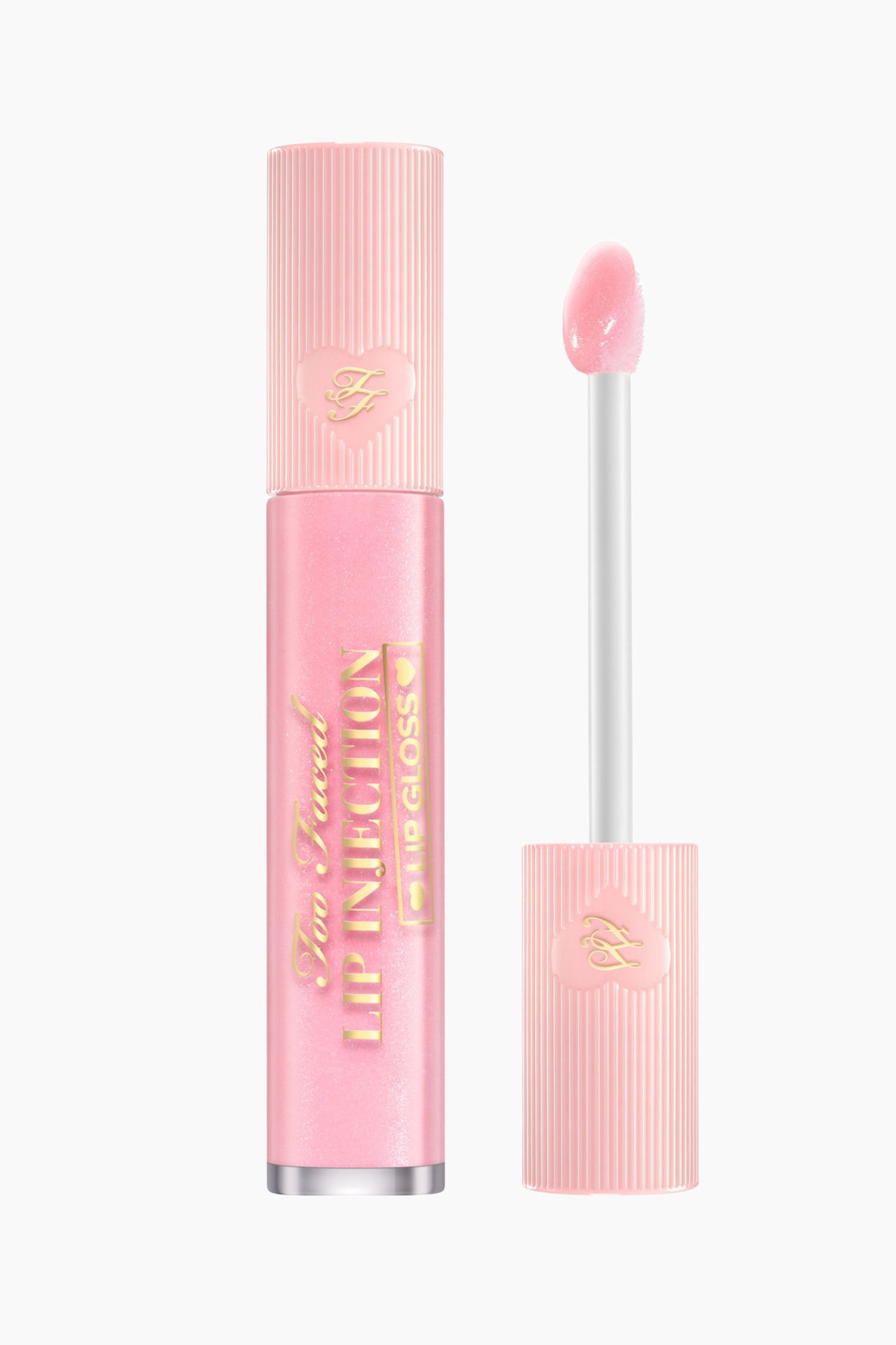 Visa större bild: Ett rosa läppglansrör står upprätt, med en räfflad kork som har en hjärtformad "F"-logotyp. Själva röret är skimrande rosa med "Too Faced LIP INJECTION LIP GLOSS" synligt i guldtext. Bredvid står applikatorstaven också upprätt och visar en generös mängd skimrande rosa glans på spetsen, medan den vilar i en matchande räfflad kork.