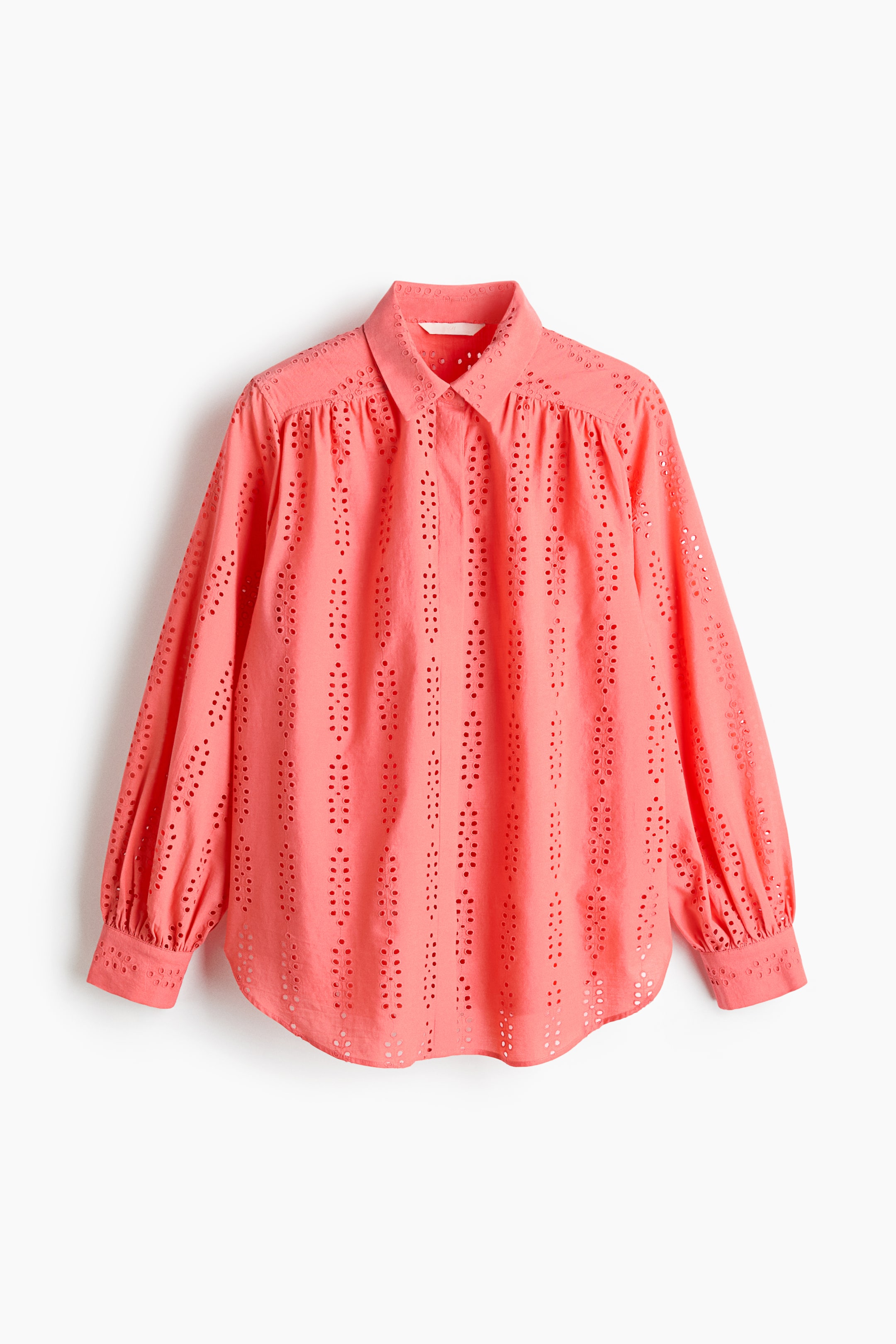 View larger image: A coral-coloured blouse is displayed front-facing, featuring a pointed collar and a button-front placket. The fabric showcases an eyelet pattern with vertical rows of small holes, designed with long, voluminous sleeves gathering at the shoulders and finishing with buttoned cuffs, all above a curved hemline.