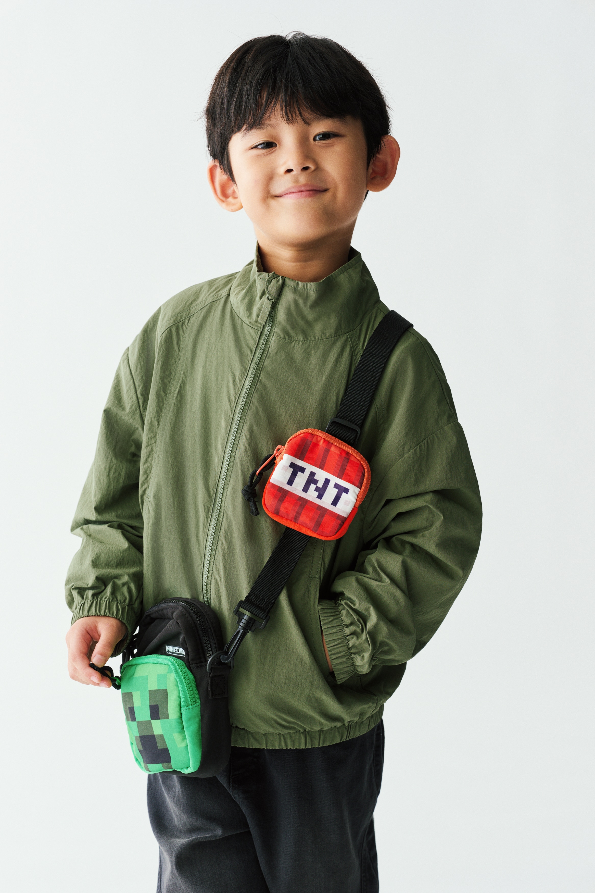 Má»t chiáº¿c Ã¡o khoÃ¡c giÃ³ nylon mÃ u xanh lÃ¡ ÄÆ°á»£c chá»¥p á» máº·t trÆ°á»c, vá»i cá» Äá»©ng, khÃ³a kÃ©o phÃ­a trÆ°á»c dÃ i toÃ n thÃ¢n, vÃ  pháº§n vai xuÃ´i vá»i ÄÆ°á»ng may raglan. Ão hiá»n thá» cÃ¡c ÄÆ°á»ng may cong á» thÃ¢n trÆ°á»c, tÃºi chÃ©o, vÃ  pháº§n chun bá»c táº¡i cá» tay Ã¡o cÃ¹ng gáº¥u Ã¡o.