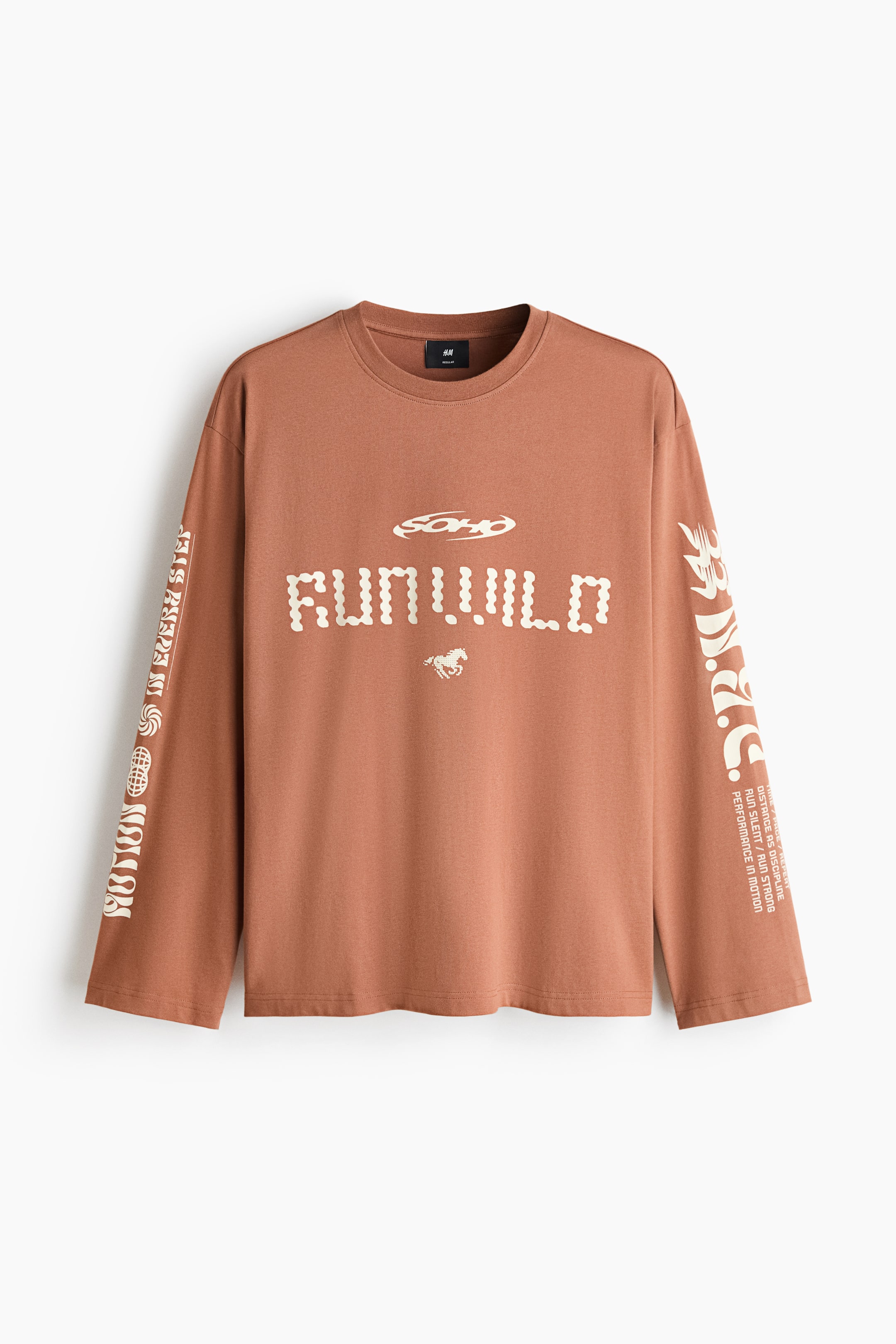 View larger image: A rust-coloured long-sleeved T-shirt is shown from the front, featuring a round, rib-trimmed neckline and dropped shoulders. The front displays "RUN.WILD" in segmented cream lettering with a small horse graphic, while both long sleeves showcase vertical text and additional graphic motifs.
