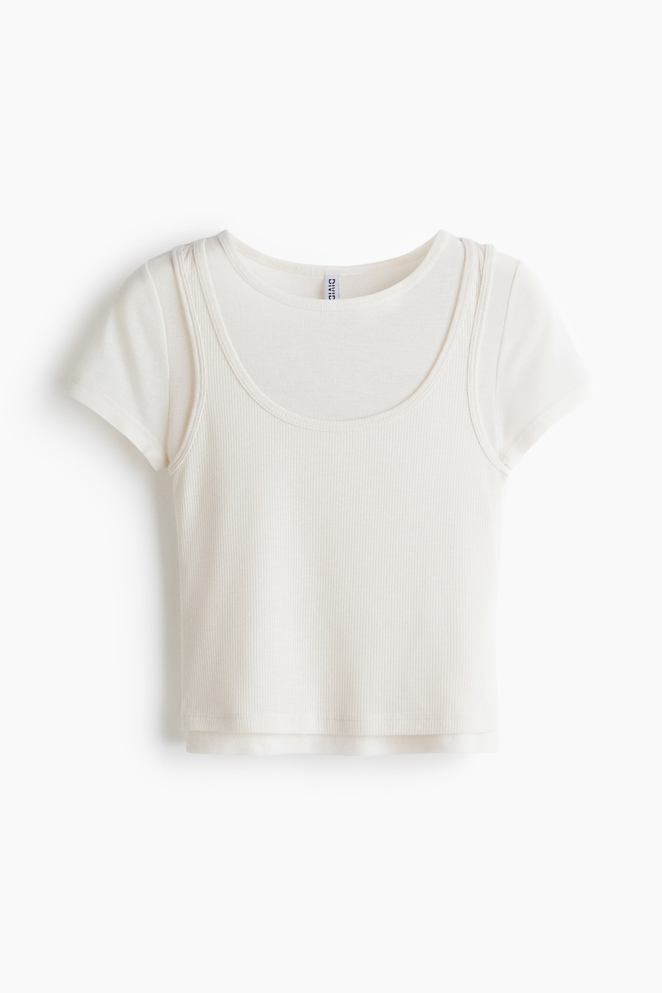 View larger image: An off-white, front-facing short-sleeved top features a ribbed main body with a deep scoop neckline. Smooth short sleeves emerge from the shoulders, creating a layered visual effect with the ribbed section, and the top is designed with a cropped length.