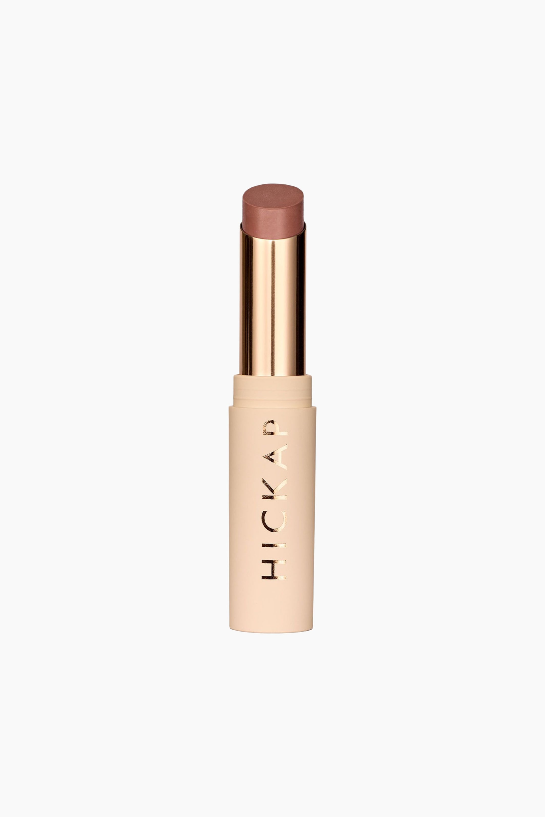 Visa större bild: Plush Pout Lipstick står upprätt och visar upp en matt beige cylindrisk bas med vertikal gyllene text som lyder "HICKAP". Ett metalliskt gyllene innerrör håller den lätt utdragna läppstiftsstiftet med platt topp i en dämpad rosénude-nyans.