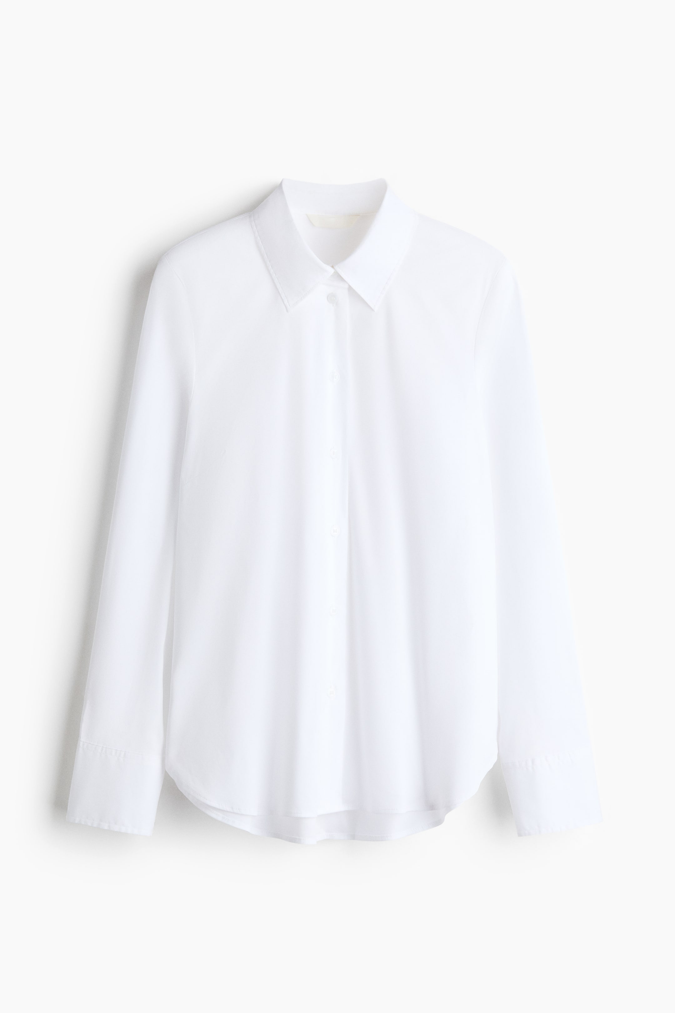 View larger image: A white long-sleeved woven shirt is displayed from the front, featuring a pointed collar and a buttoned placket. It is showing buttoned cuffs and a rounded hem.